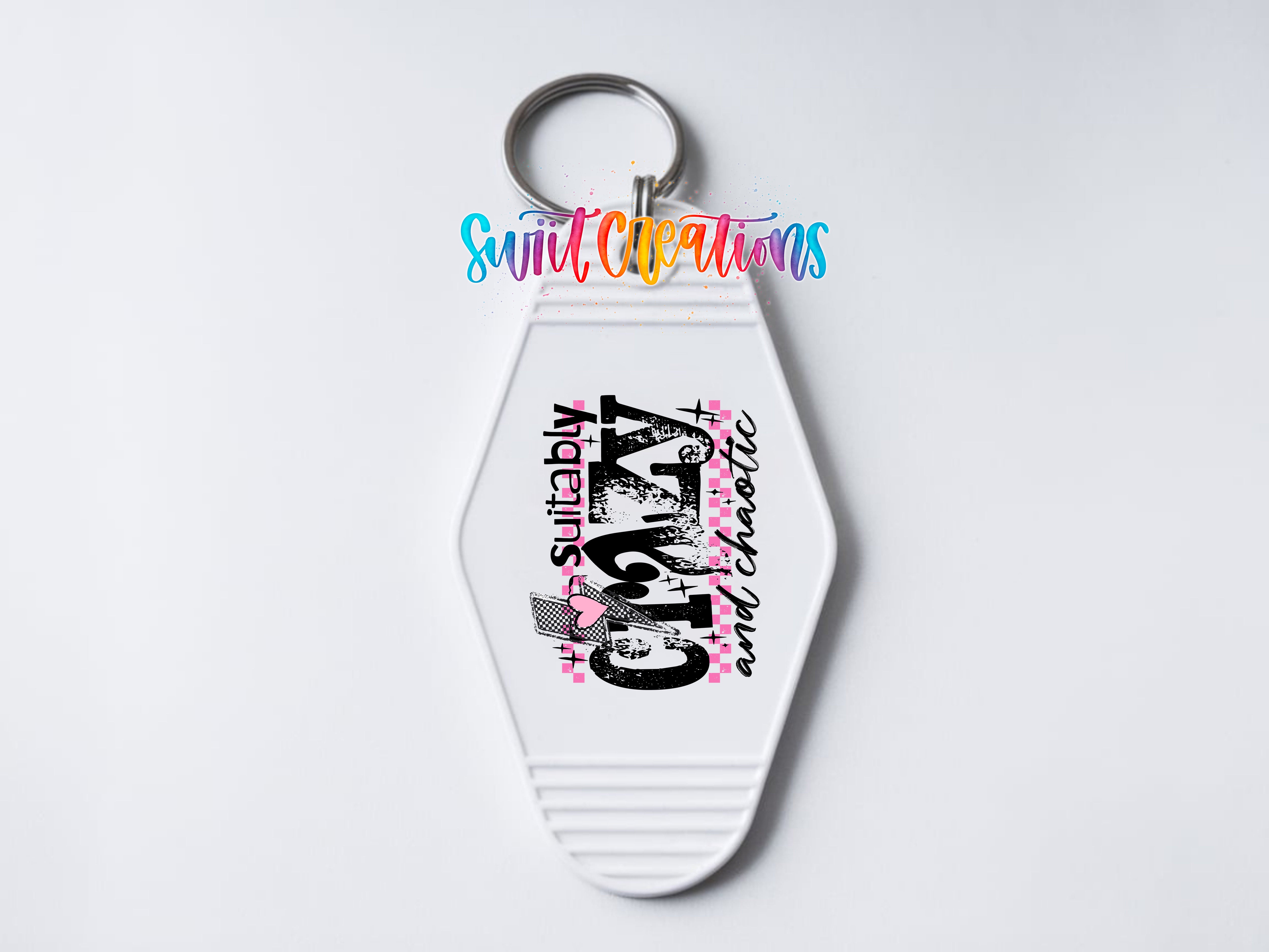 A white keychain with a colorful design and text on it.