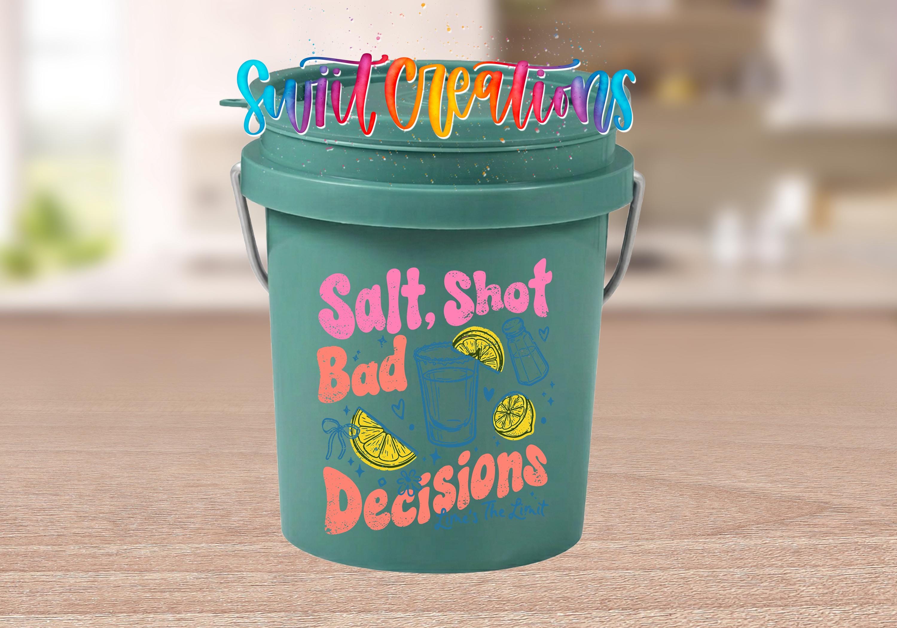 A green bucket with colorful text and illustrations on it, placed on a wooden surface.