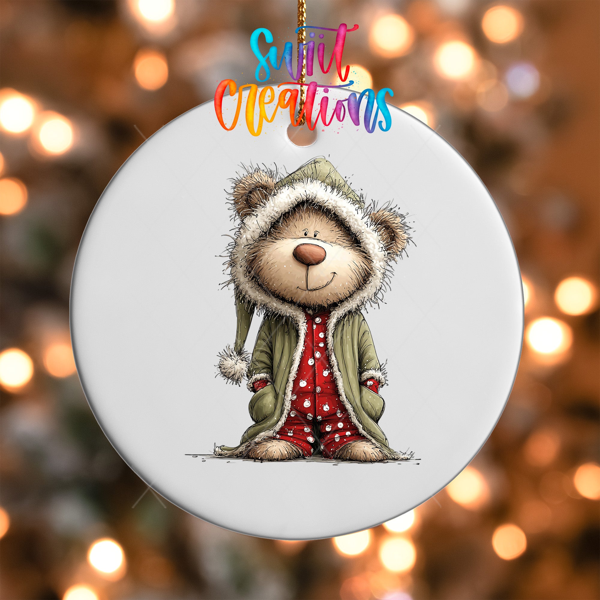 A white ornament with a cartoon illustration of a bear wearing a green coat and red polka dot pants, smiling.