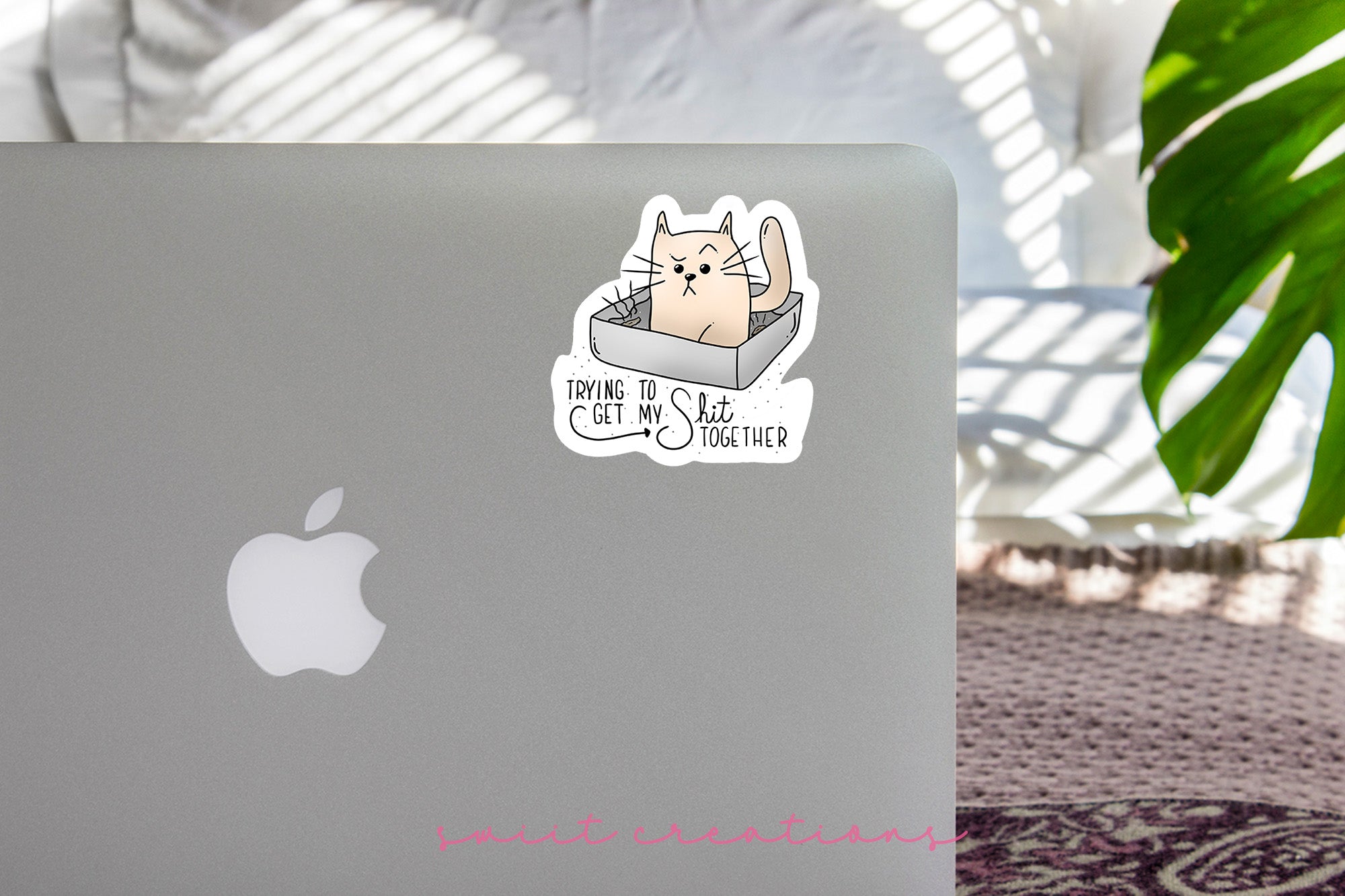a laptop with a sticker of a cat in a box