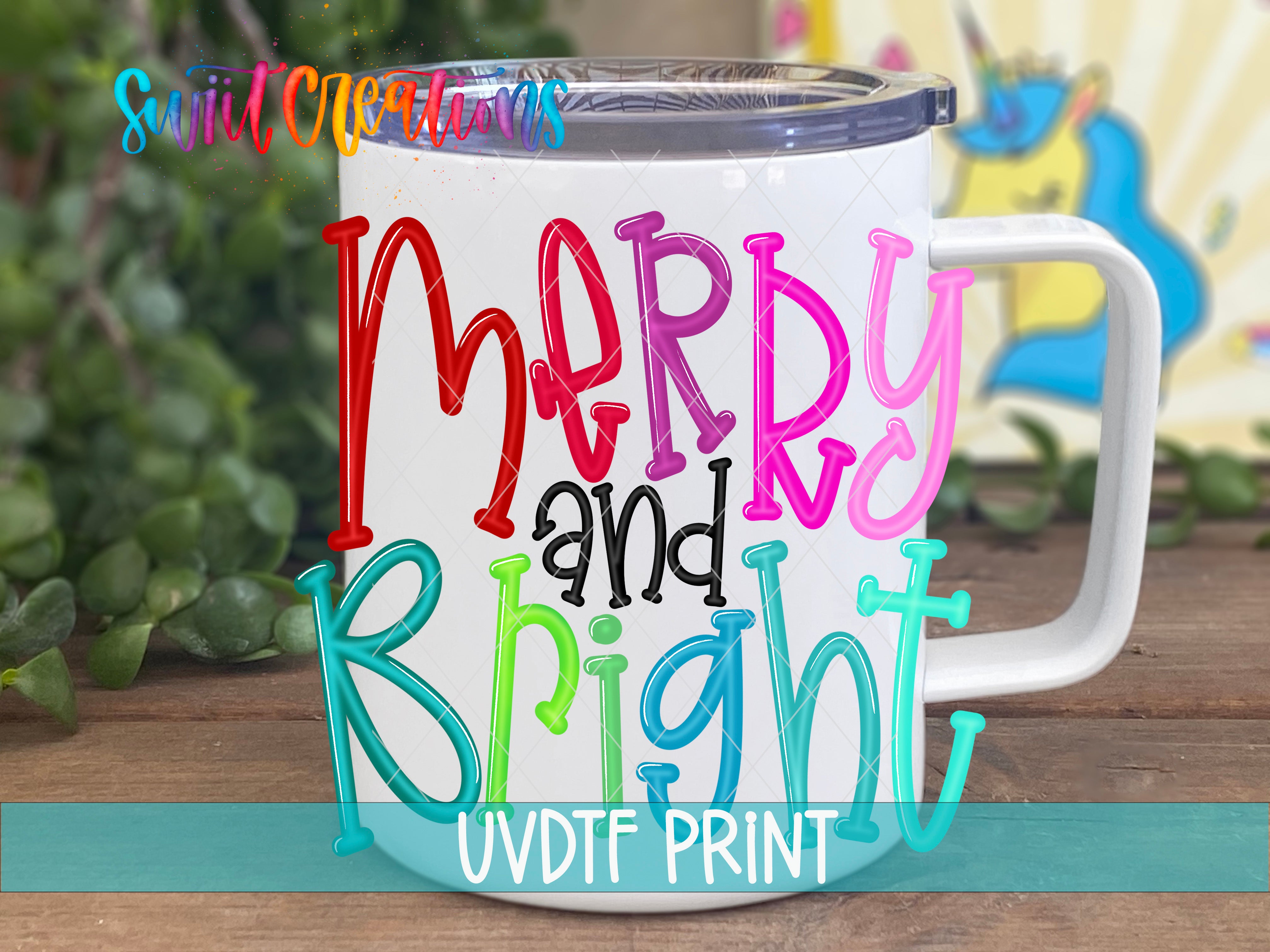 A white mug with colorful text that says "Merry and Bright" on it, placed on a wooden surface with some greenery in the background.