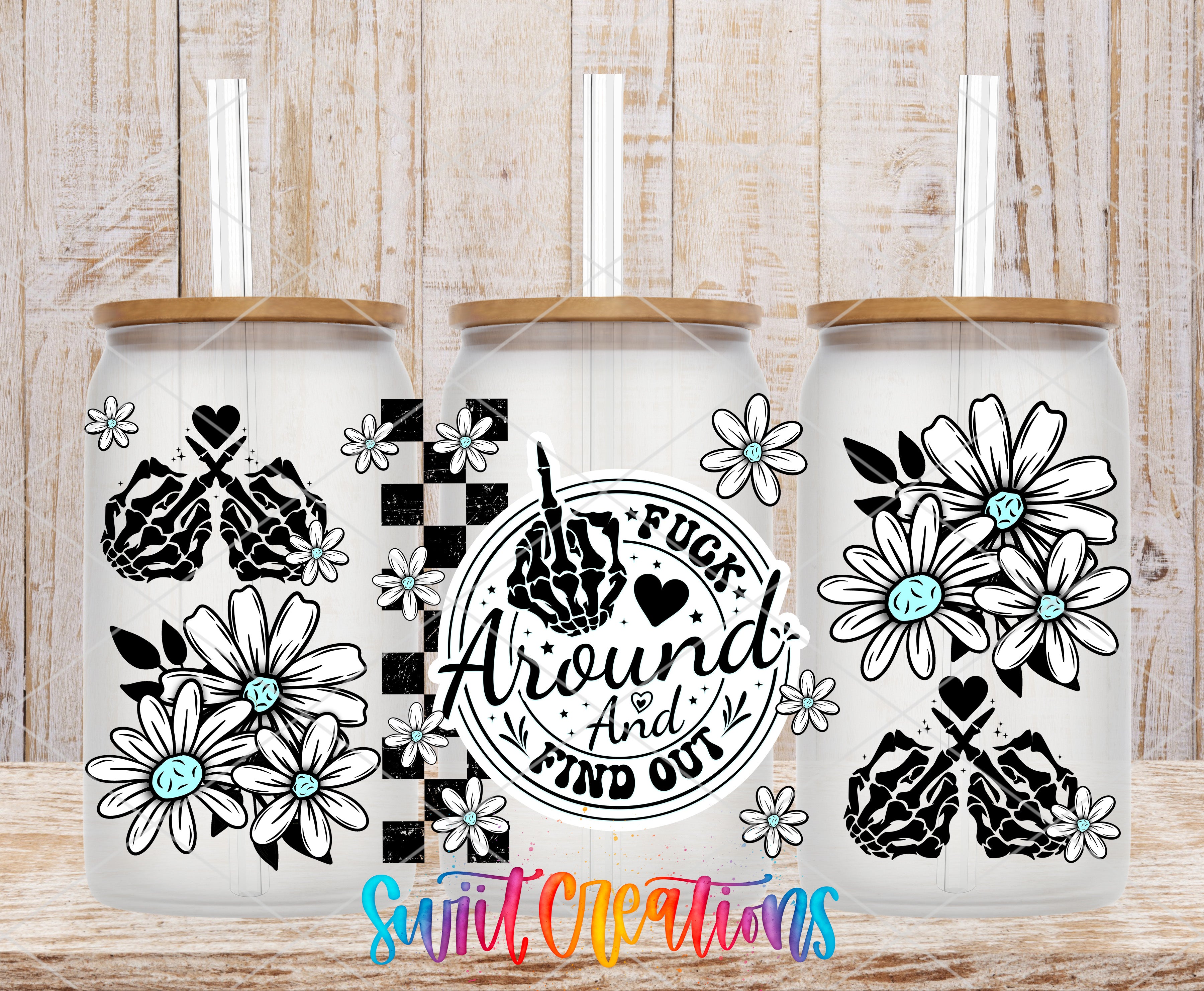 three glass tumblers with floral designs and text on them, placed on a wooden surface.