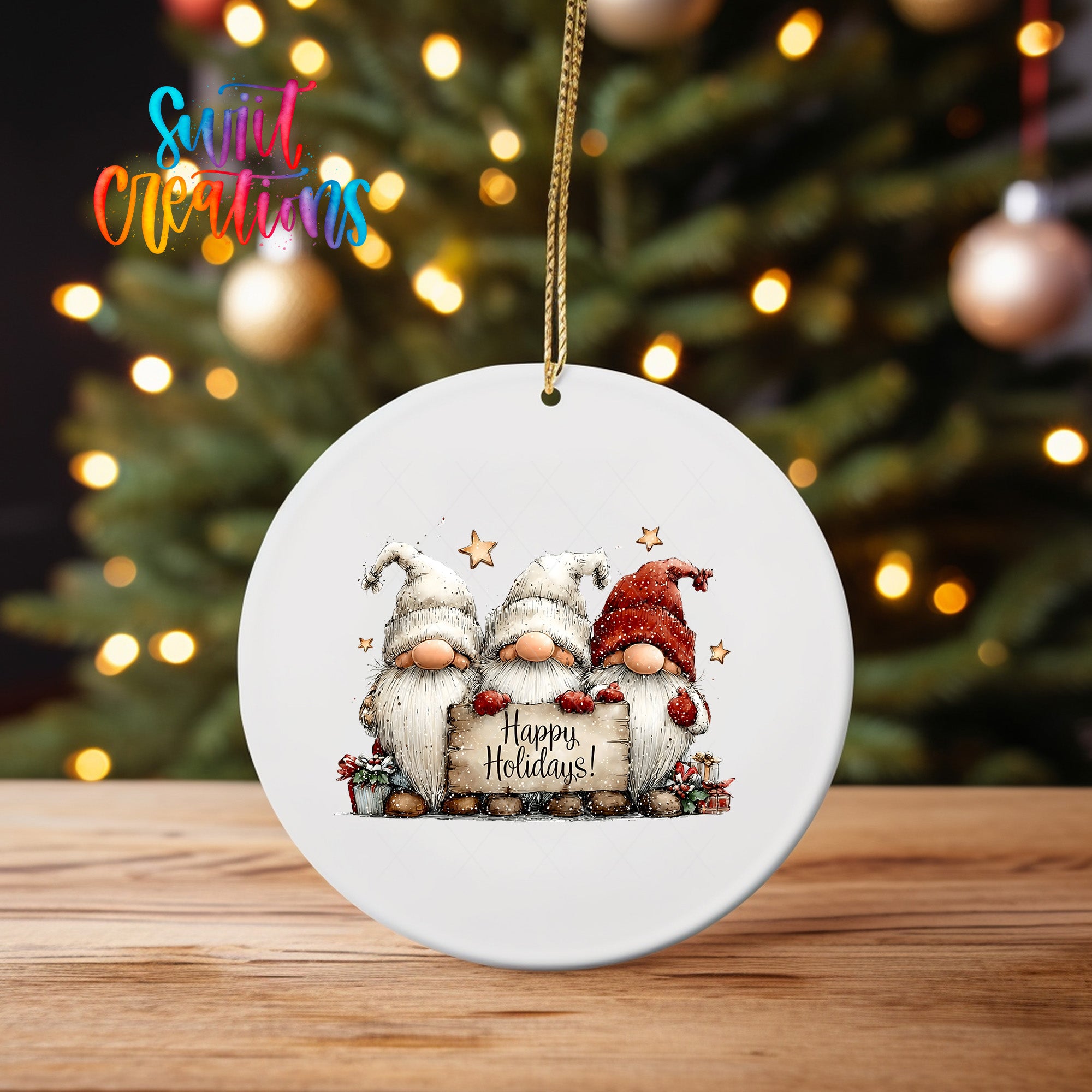 A white ceramic ornament featuring three gnomes holding a sign that says "Happy Holidays!" against a blurred background of Christmas lights.