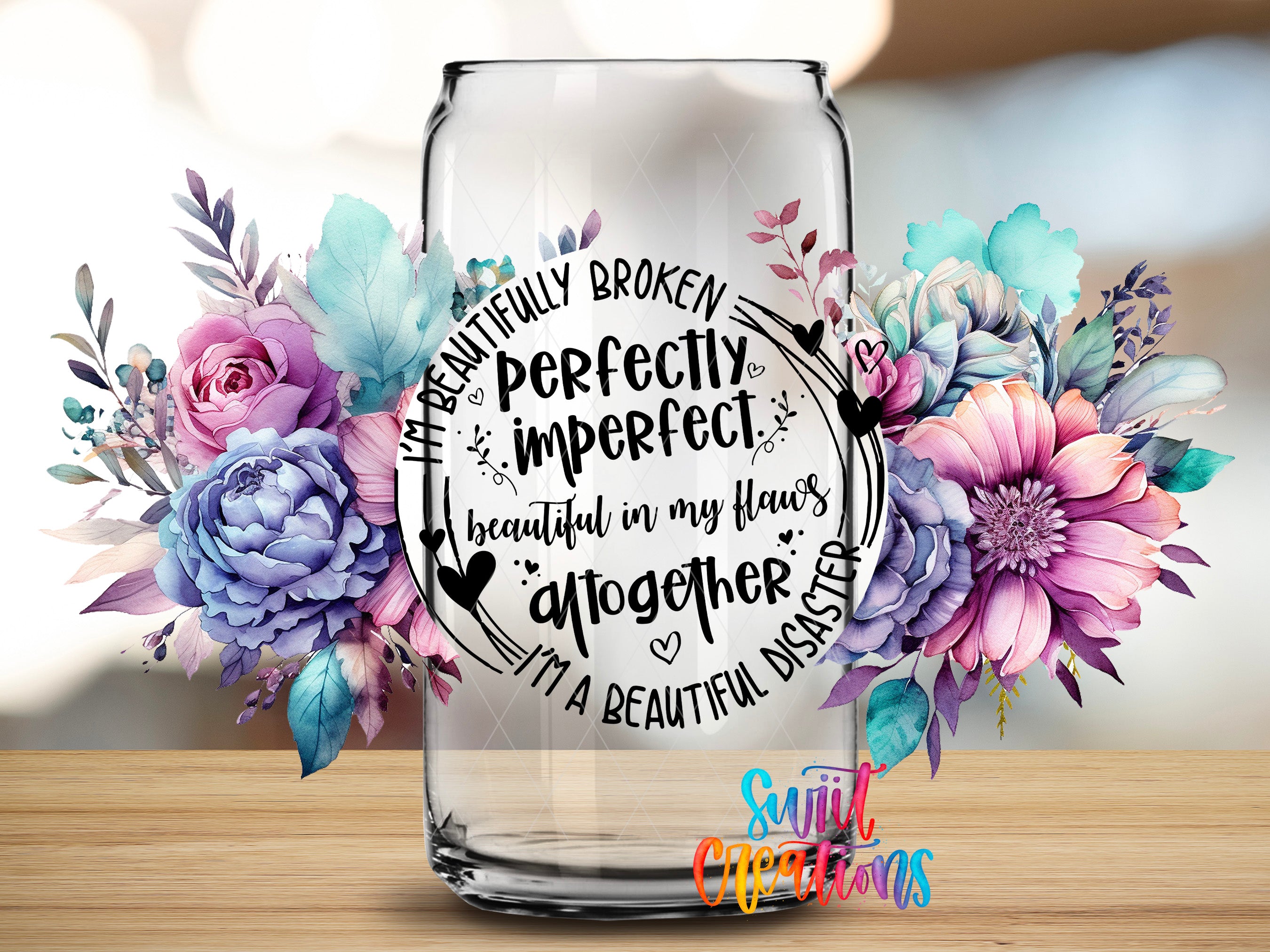 a glass jar with a floral design and text inside it, surrounded by colorful flowers.