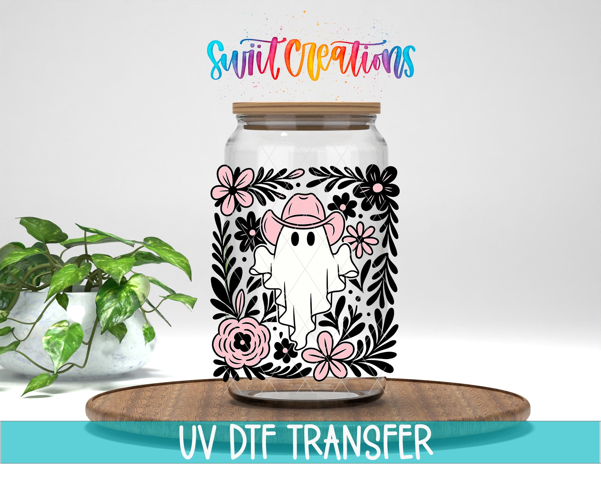 a glass jar with a floral design and a ghost character on it, placed on a wooden surface.