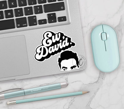a laptop with a sticker of a man's face next to a mouse