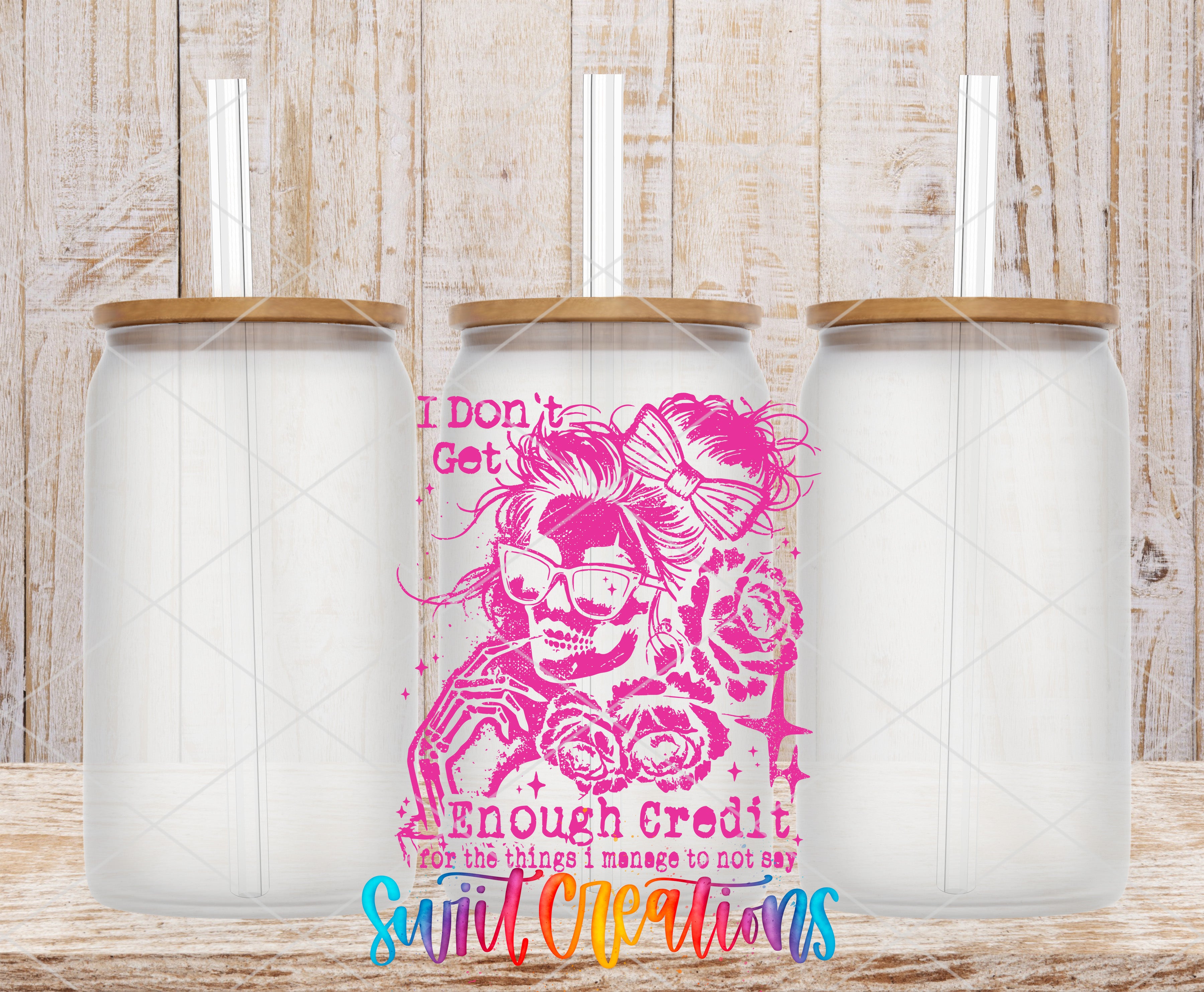 three glass jars with lids, each containing a straw. The jars are arranged in a row, with the middle jar having a pink and white design featuring a skull and flowers. The text "I don't get enough credit for the things I manage to not say" is displayed in the center of the image.