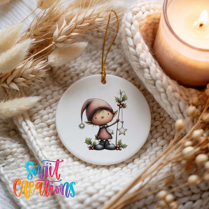 A white ceramic ornament featuring a small elf wearing a pink hat and holding a star, surrounded by dried flowers and a lit candle.
