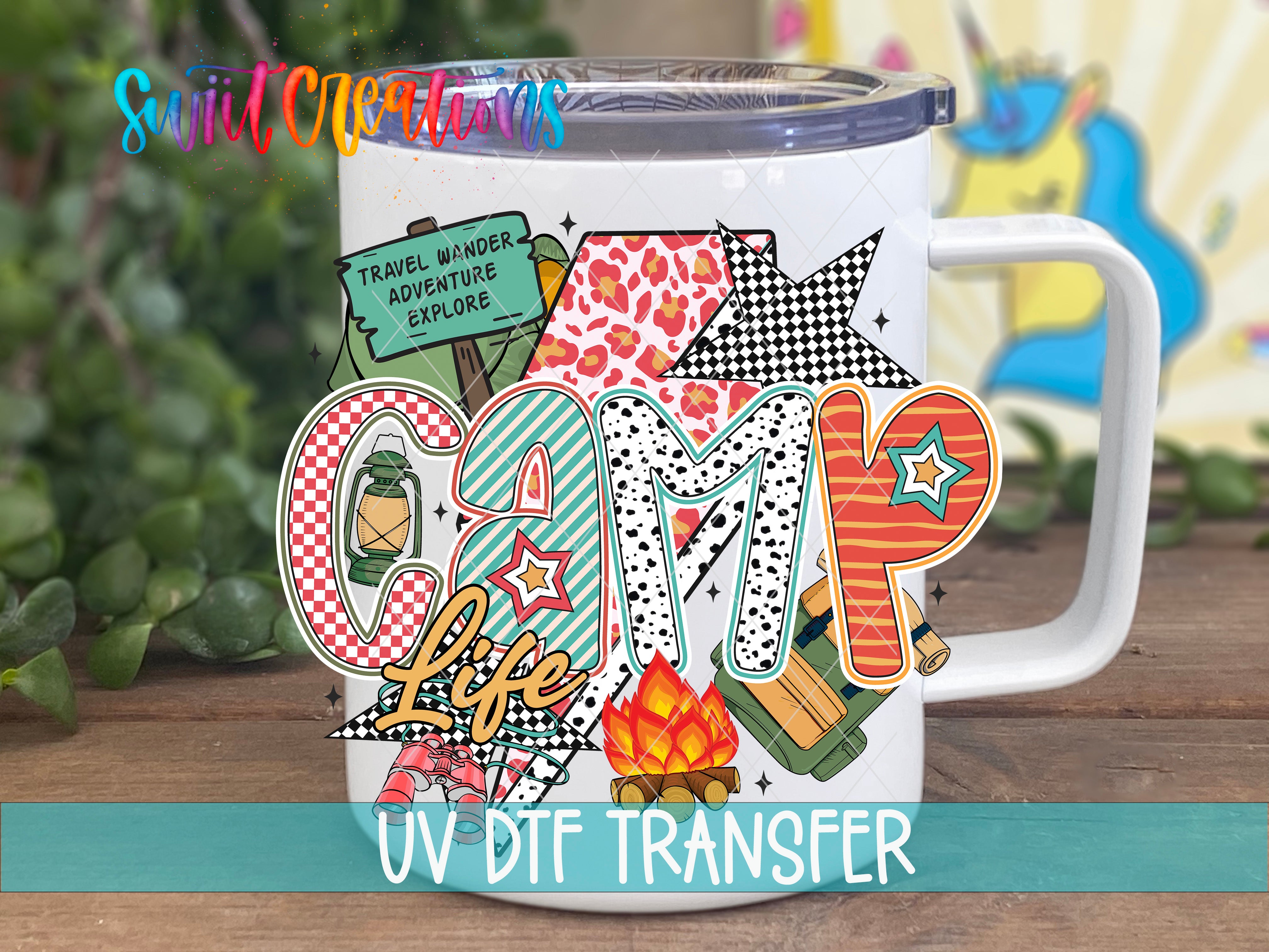 A white mug with a colorful, cartoonish design featuring the word "Camp" and various camping-related elements such as a tent, campfire, and star.
