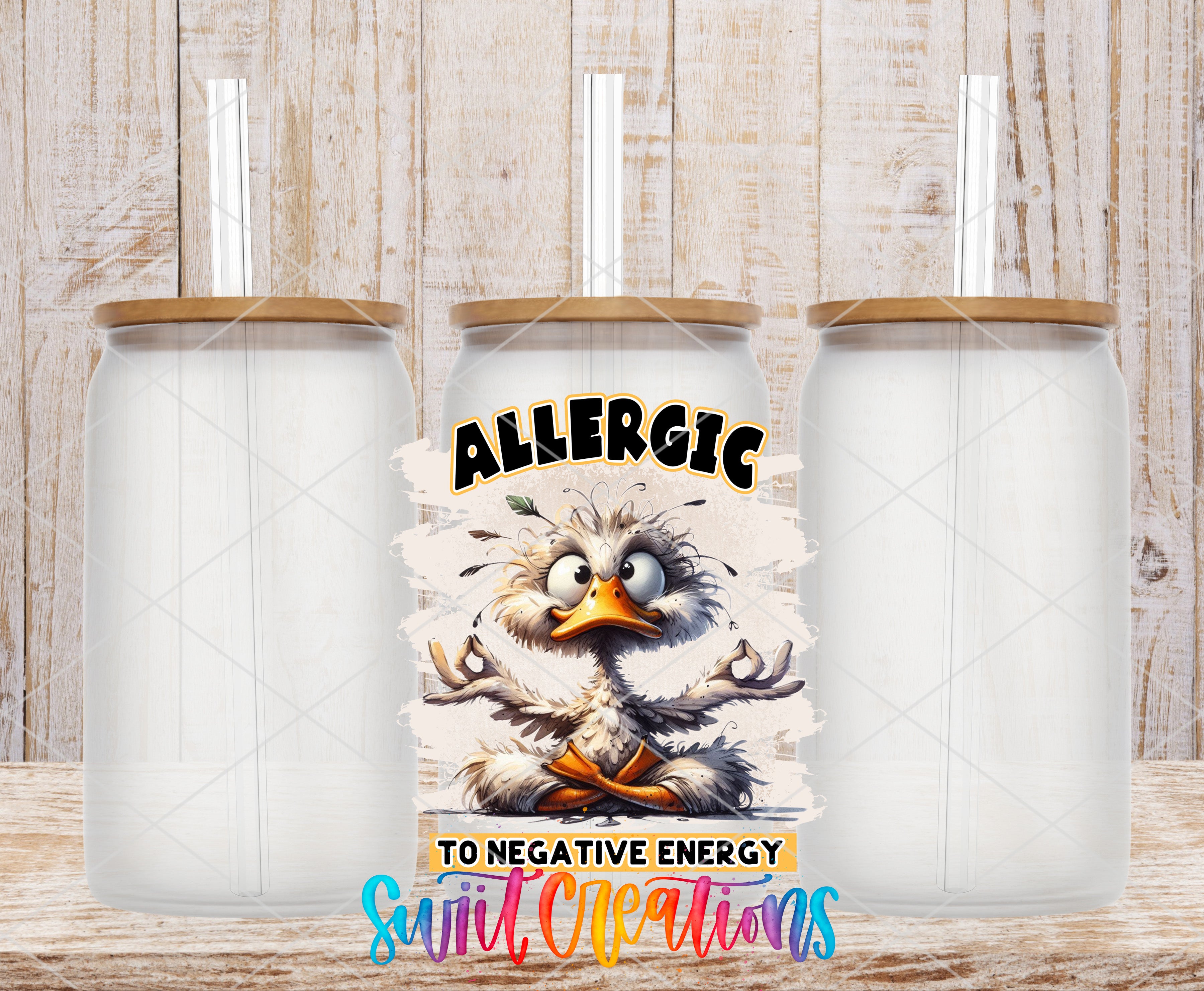 a cartoon duck with a straw, accompanied by the text "ALLERGIC TO NEGATIVE ENERGY" and "Suit Creations".