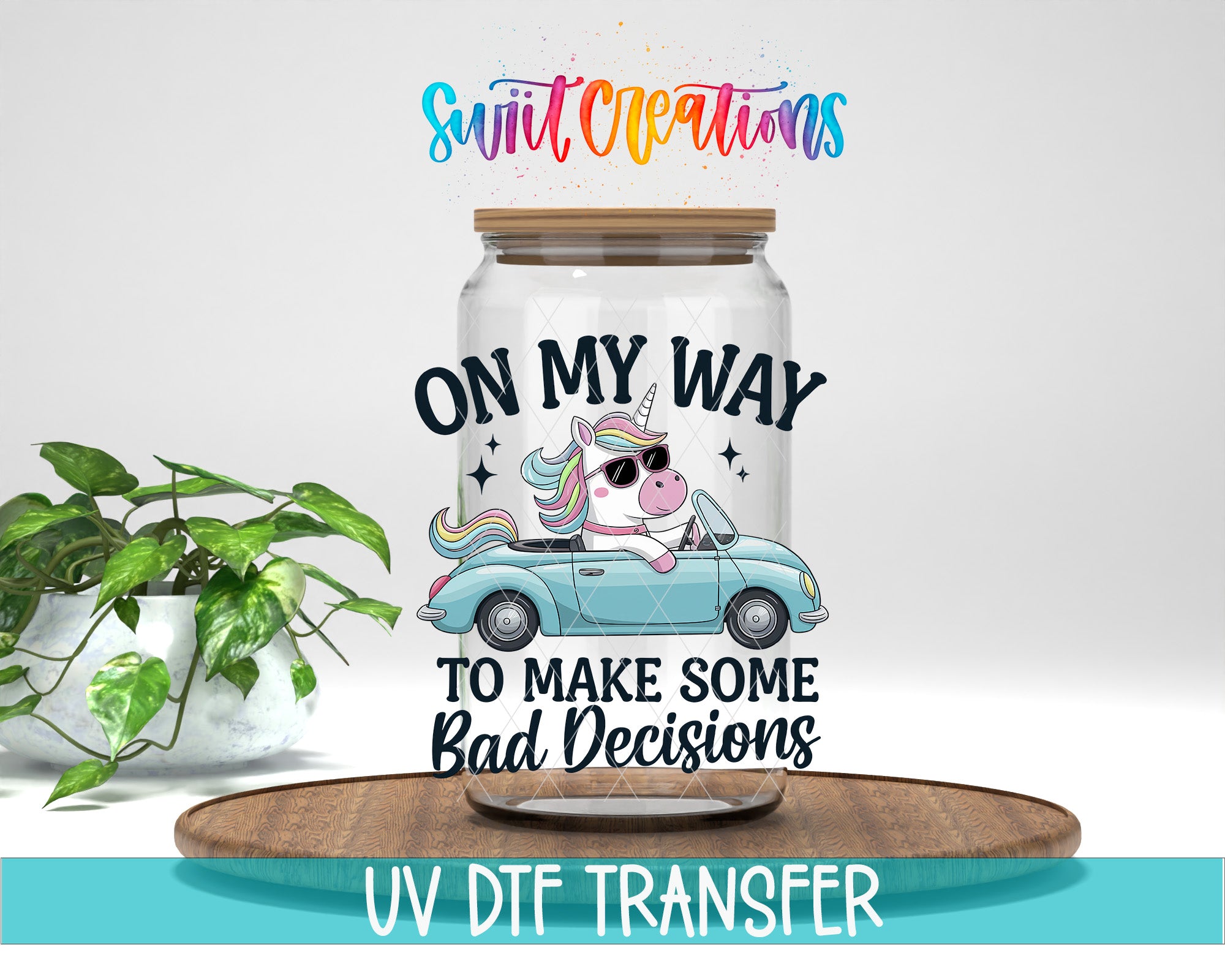 a clear glass jar with a cartoon unicorn and the text "ON MY WAY TO MAKE SOME BAD DECISIONS" printed on it. The jar is placed on a wooden tray, and there is a potted plant in the background.
