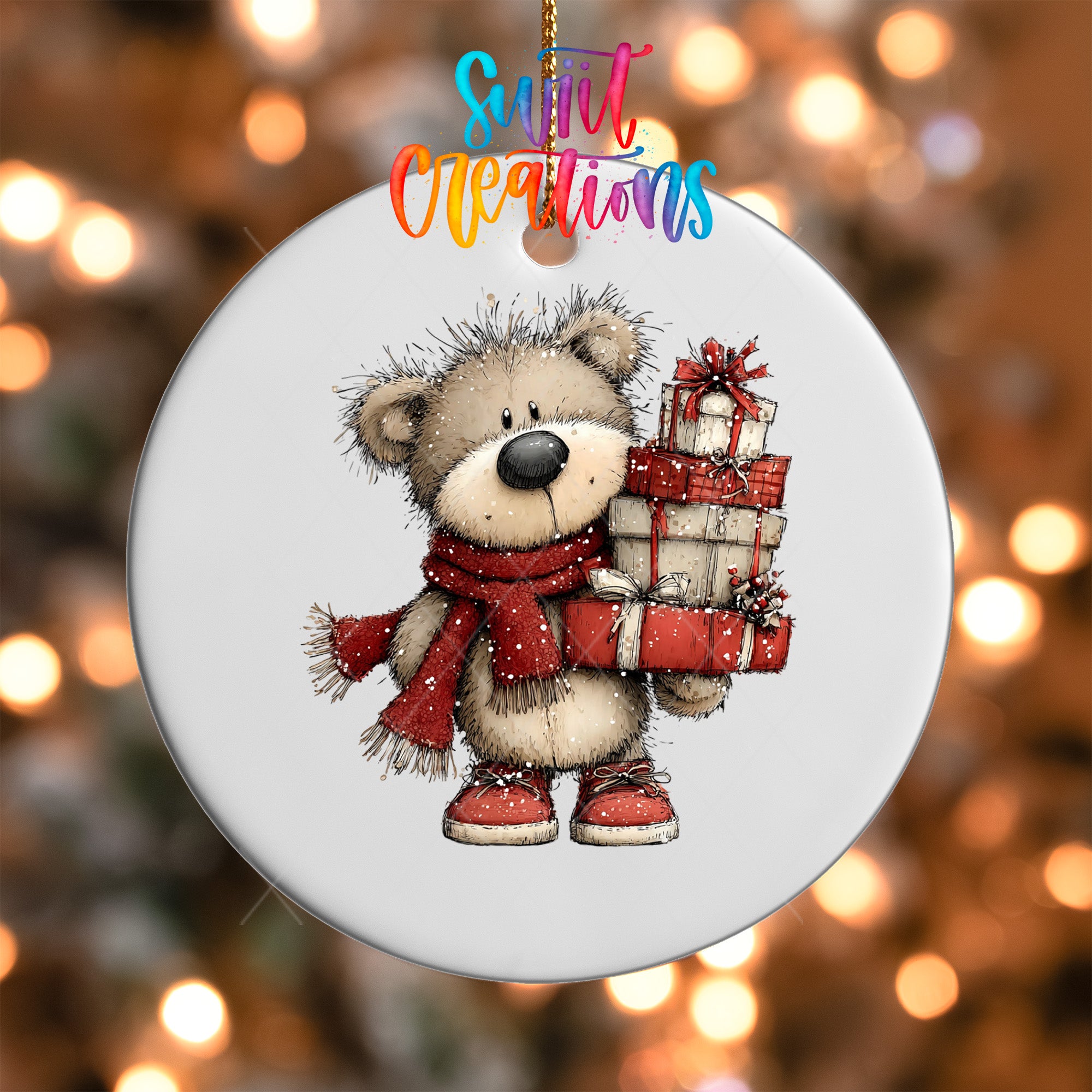 A white ornament with a teddy bear wearing a red scarf and holding a stack of wrapped presents.