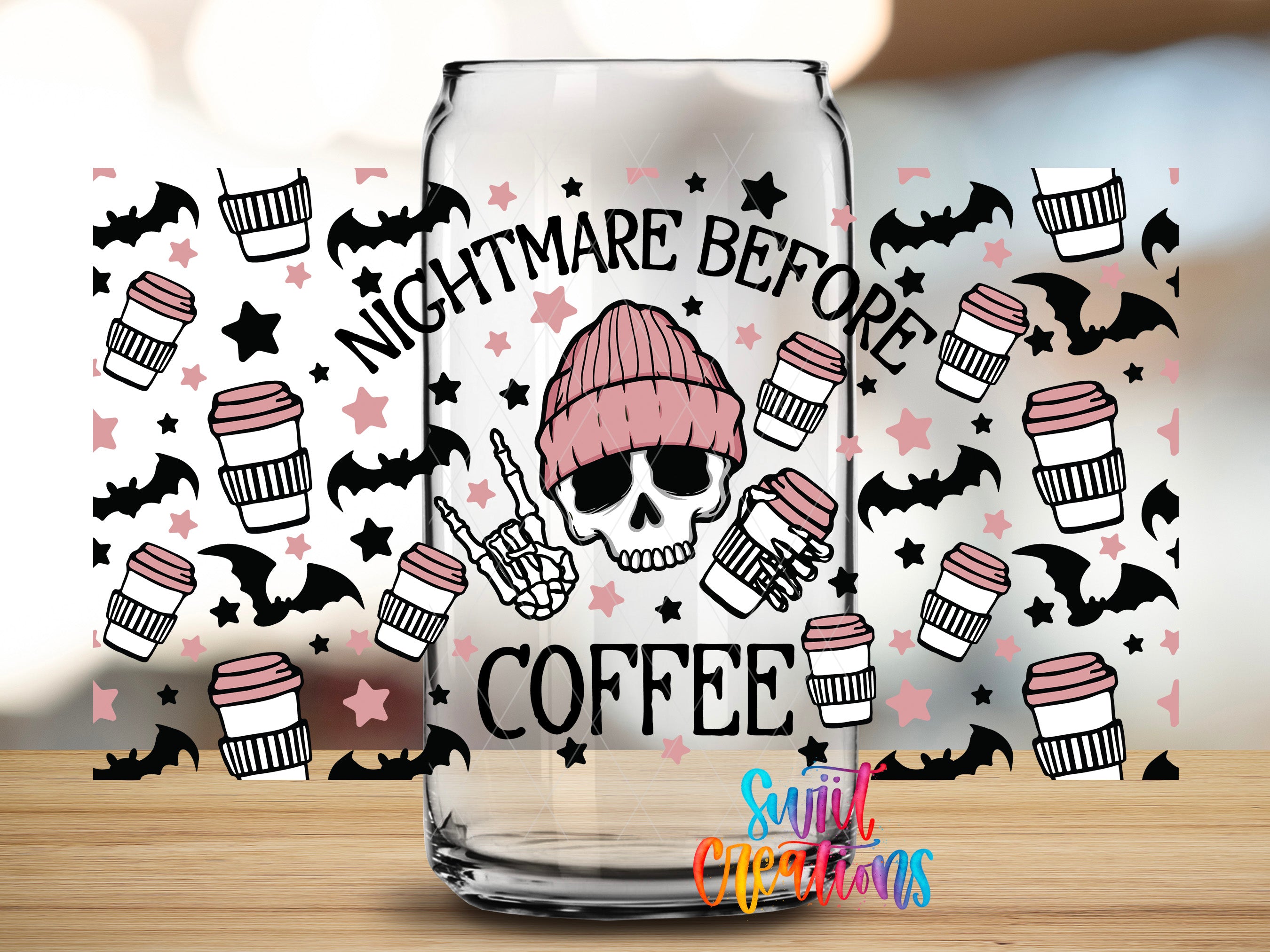 a glass mug with a design that includes a skull wearing a knit cap, coffee cups, and bats, along with the text "NIGHTMARE BEFORE COFFEE".