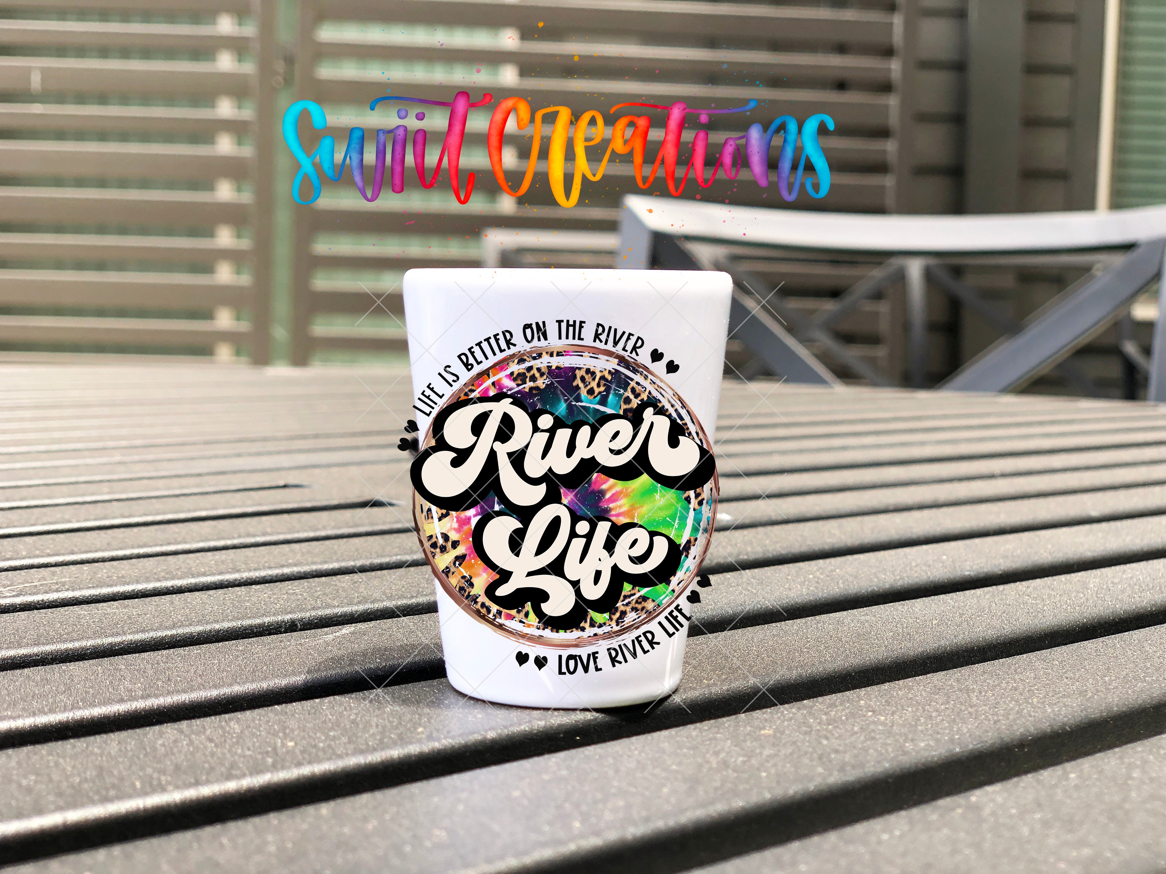 A white cup with a colorful, abstract design sits on a wooden surface, with a colorful text overlay in the background.
