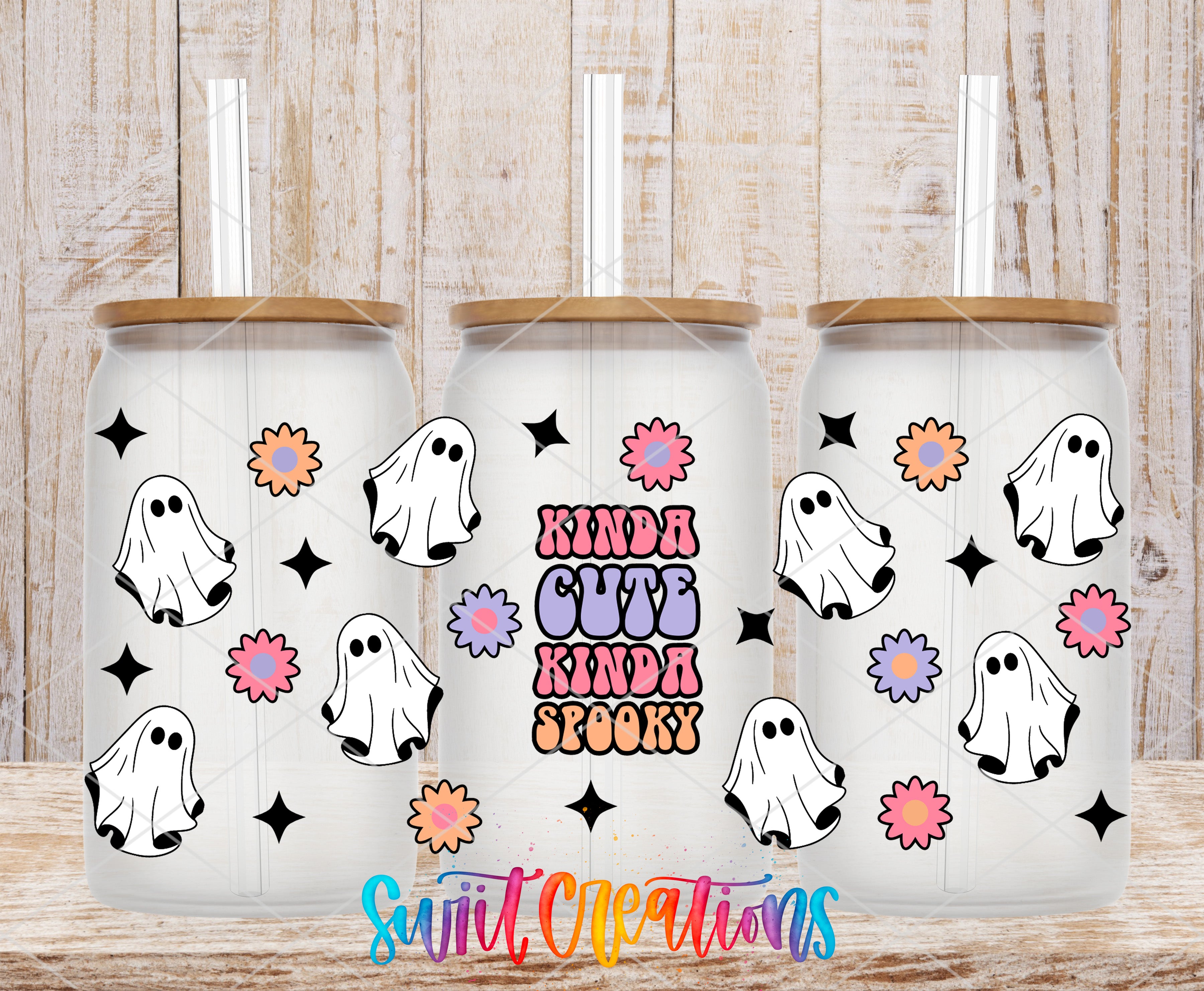 three glass tumblers with a Halloween-themed design. Each tumbler has a white base and a brown lid, and the design includes ghost-like silhouettes and colorful flowers. The text "KINDA CUTE KINDA SPOOKY" is displayed on the front of the tumblers, and the phrase "Swift Creations" is written at the bottom of the image.