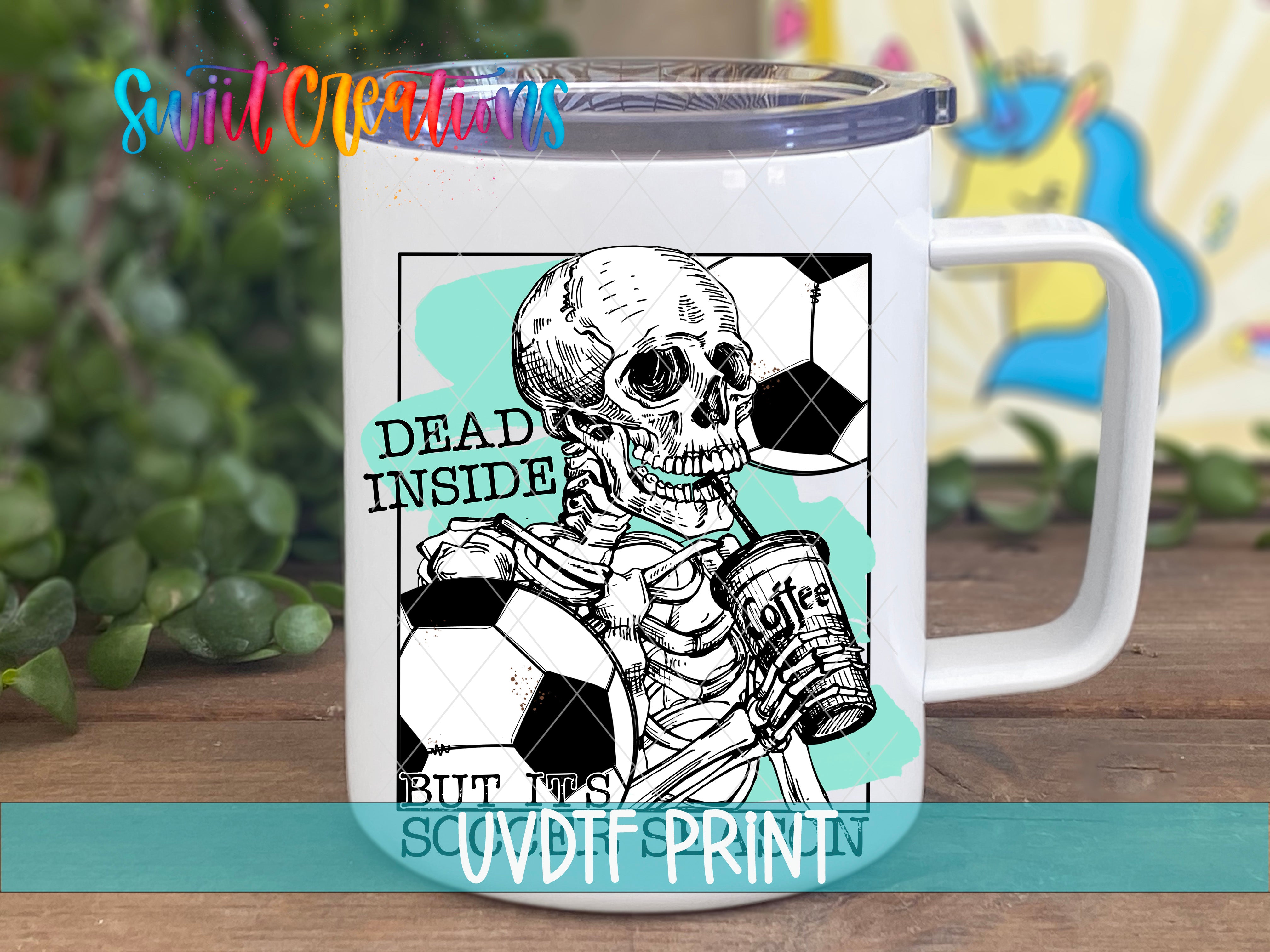 A white mug with a black and white illustration of a skeleton holding a soccer ball and a cup of coffee, accompanied by the text "Dead inside but not this" and "SCUDFRINT".