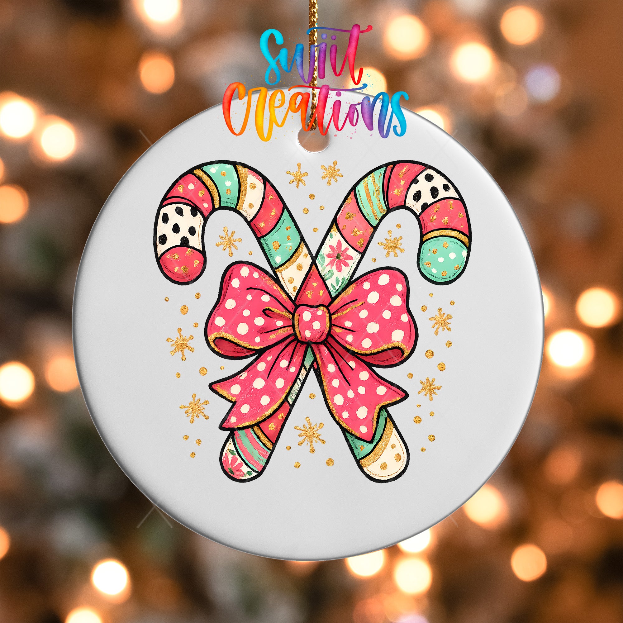 A white ornament with a bow and colorful candy cane design, hanging against a blurred background with colorful lights.
