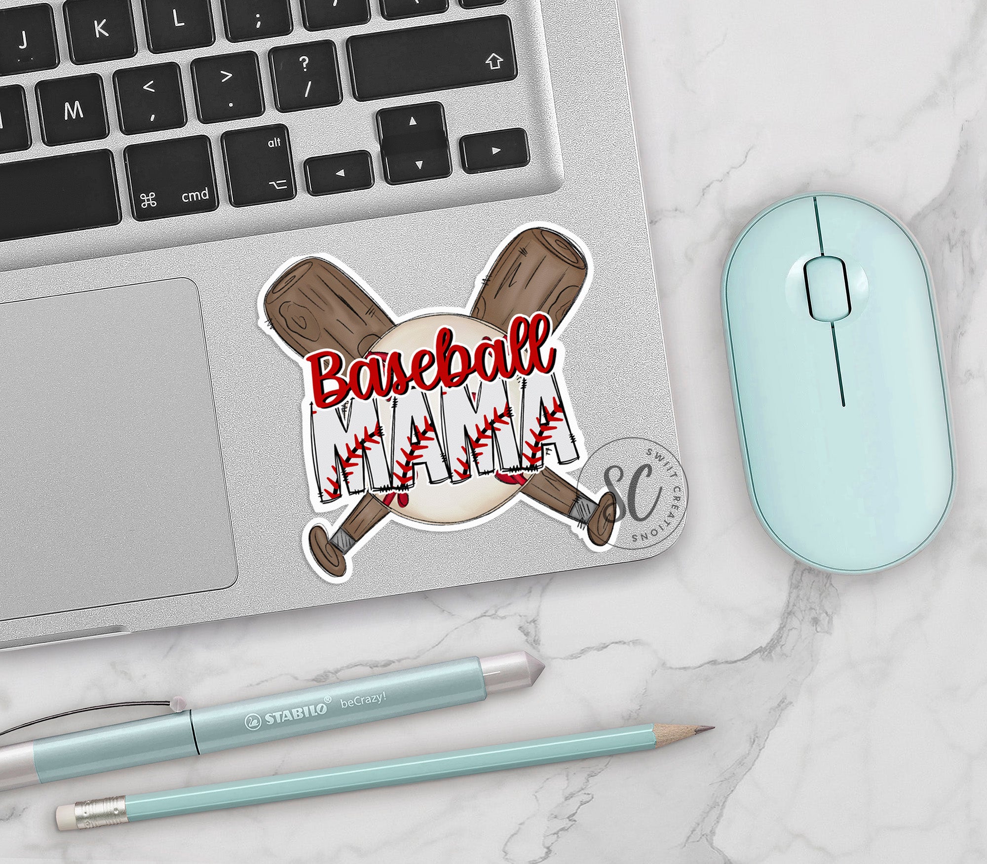 a laptop with a baseball sticker on it next to a mouse