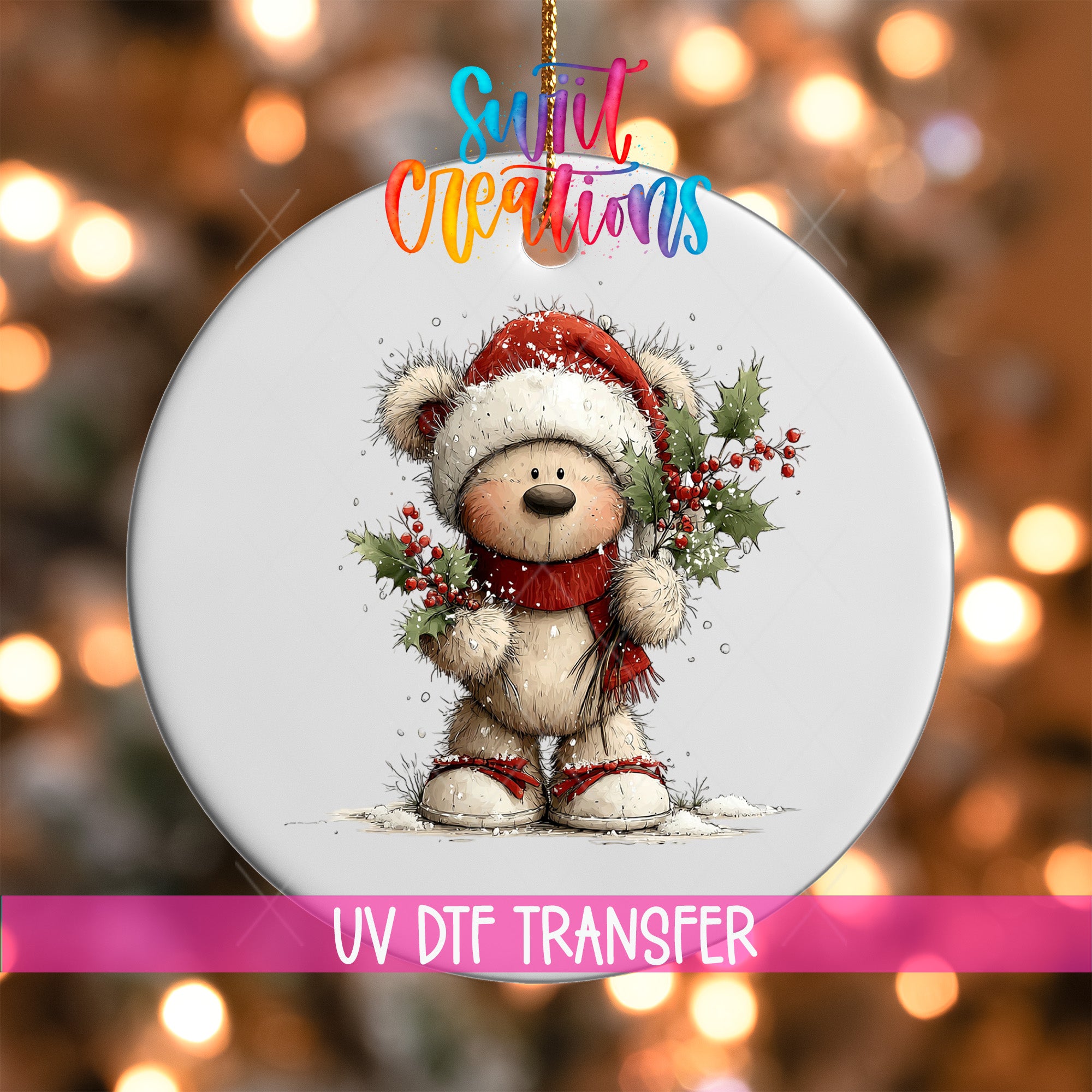 A white ornament with a teddy bear wearing a Santa hat and holding holly and berries, set against a blurred background with Christmas lights.