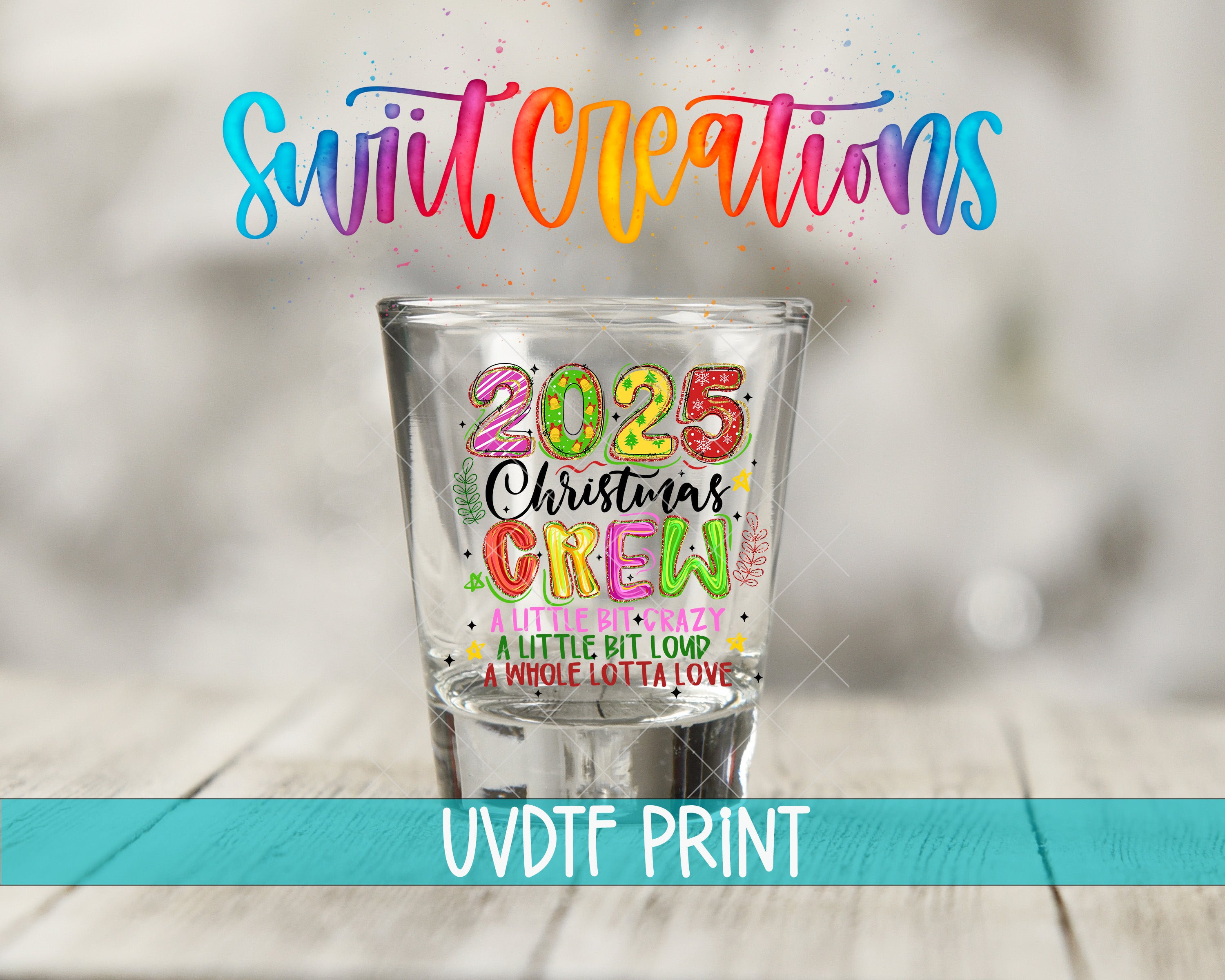 A shot glass with a colorful design and text on it, placed on a wooden surface.