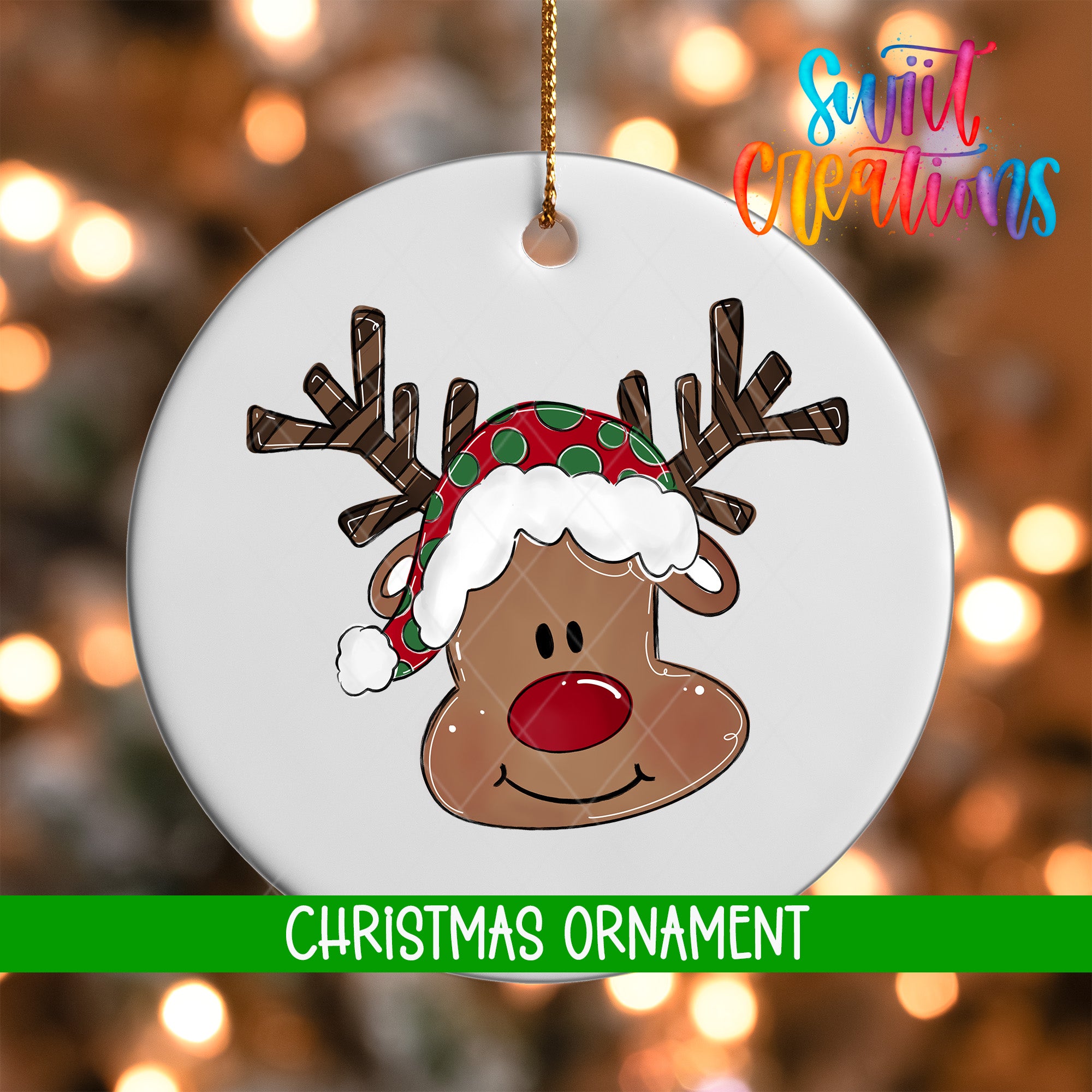 A white Christmas ornament with a smiling reindeer wearing a red and green hat, set against a blurred background of colorful lights.