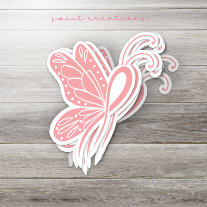 a pink butterfly sticker sitting on top of a wooden table