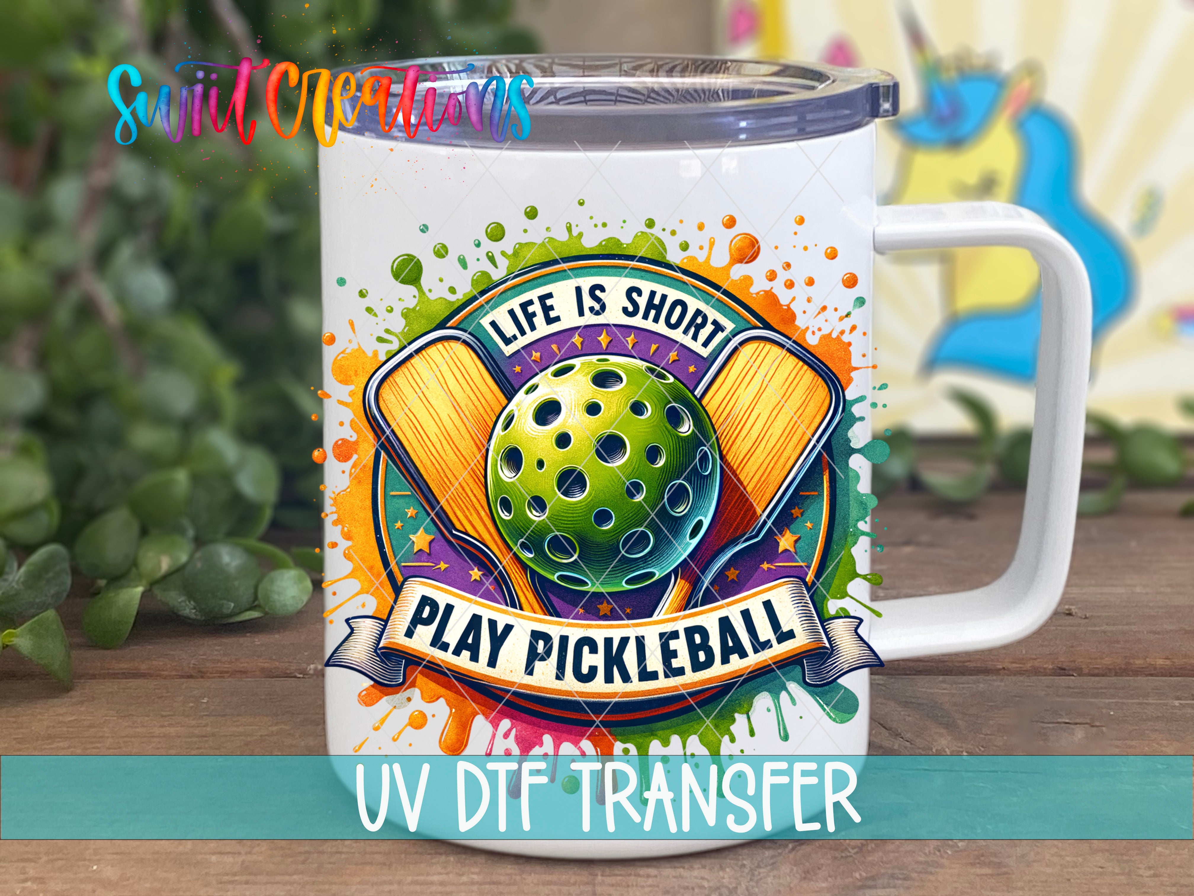 A white mug with a colorful design featuring a pickleball and the text "Life is short, play pickleball" printed on it.