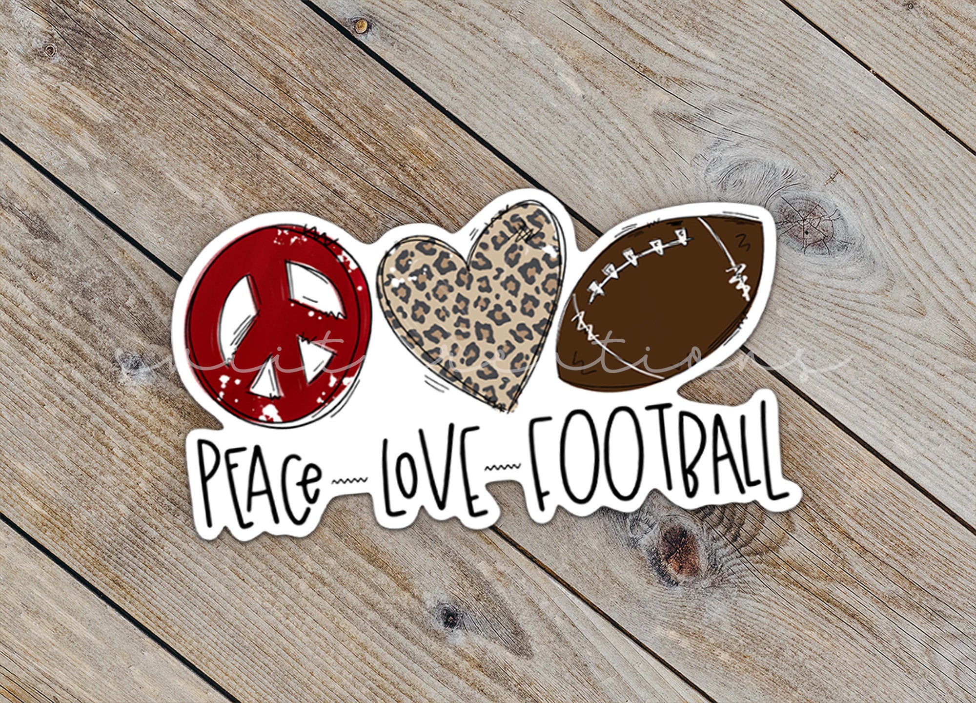 a peace love football sticker sitting on top of a wooden floor