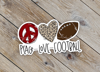a peace love football sticker sitting on top of a wooden floor