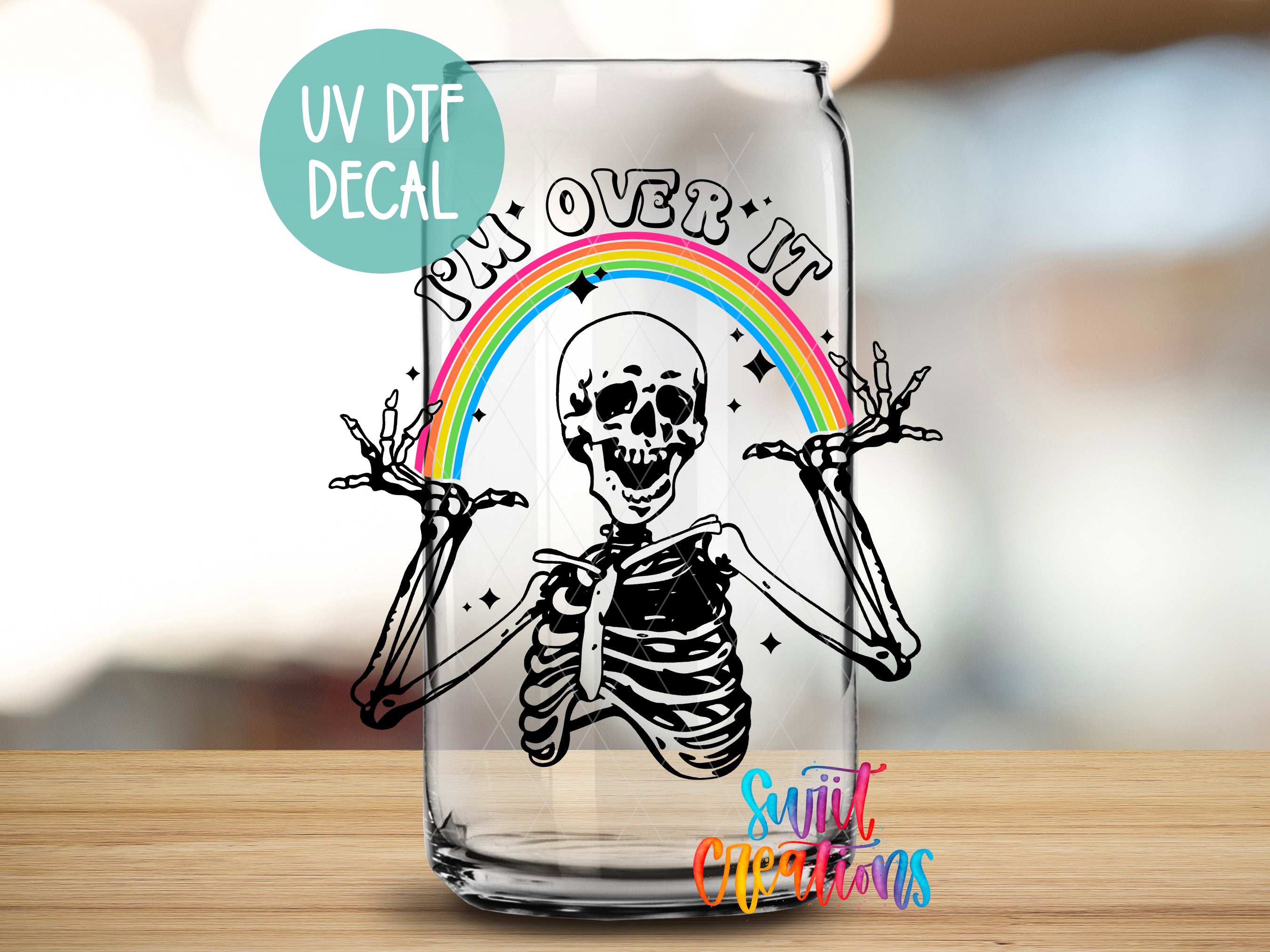 a glass with a picture of a skeleton and a rainbow