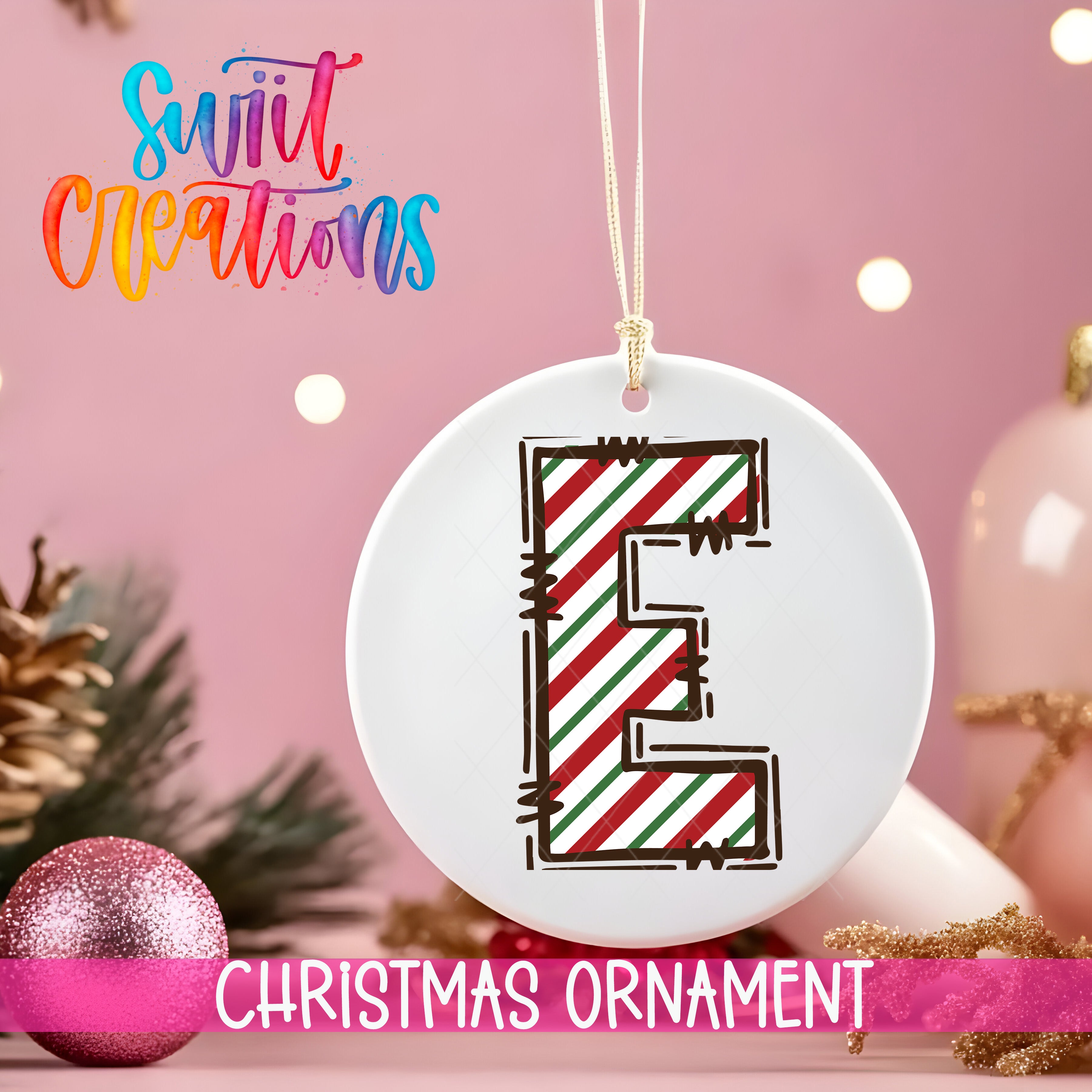 a white Christmas ornament with a colorful design, hanging on a string against a pink background.