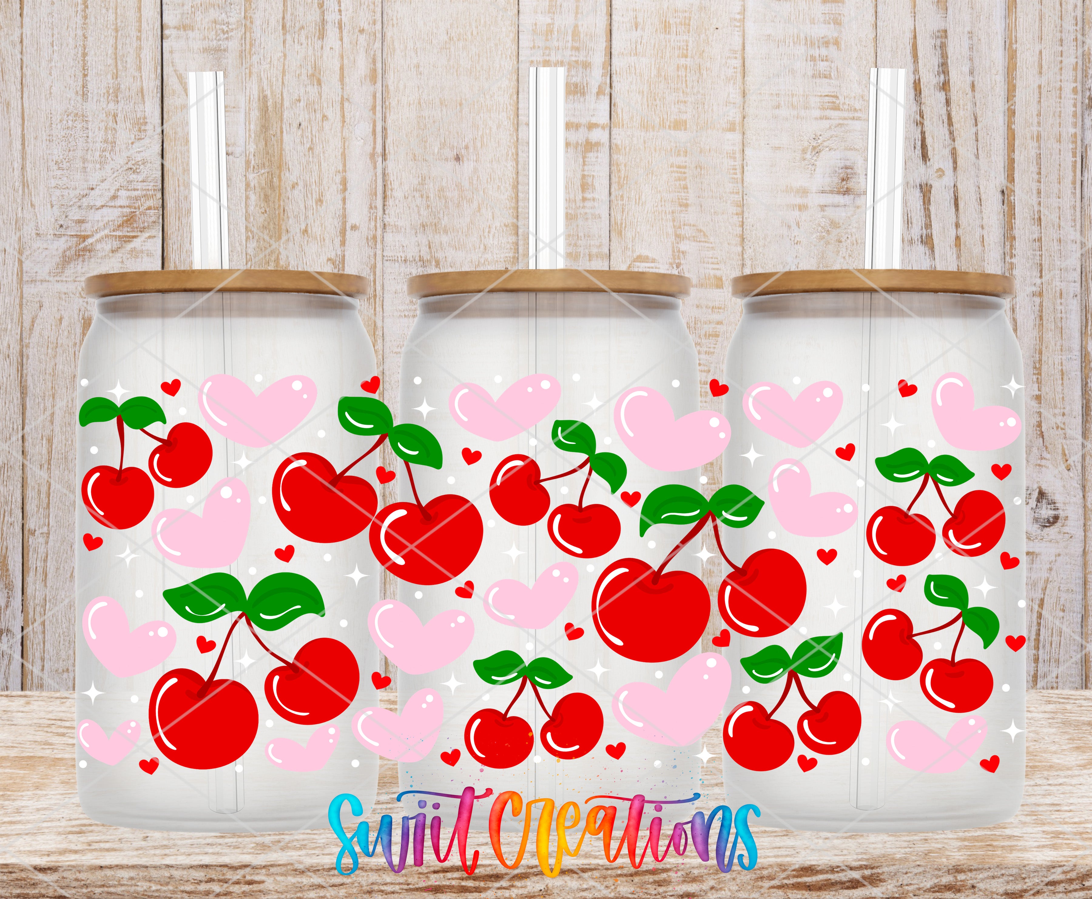 Three glass jars with lids, each decorated with a pattern of red cherries and hearts on a white background.