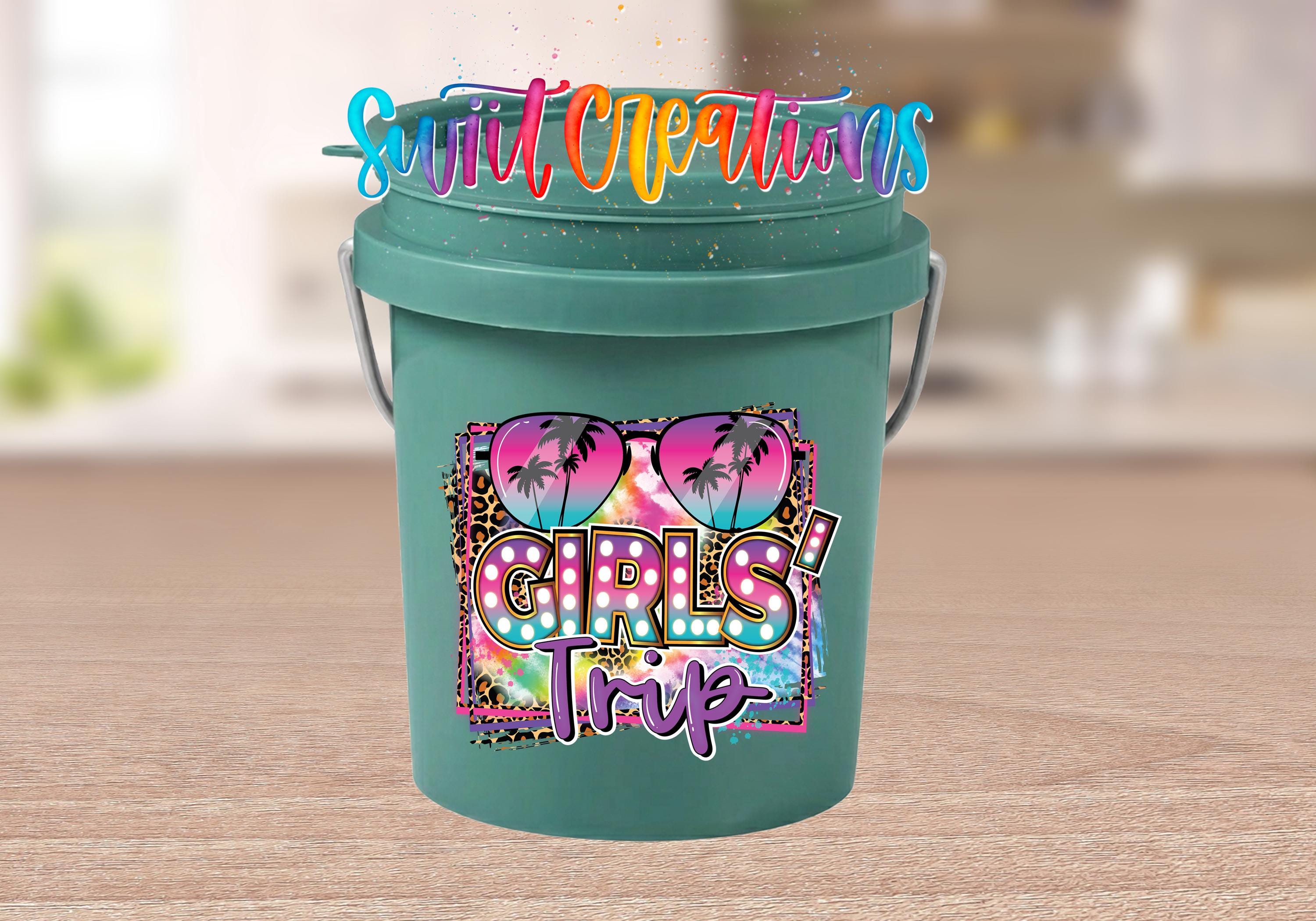 A green bucket with a colorful, stylized design featuring sunglasses, palm trees, and the text "Girls Trip" printed on it.