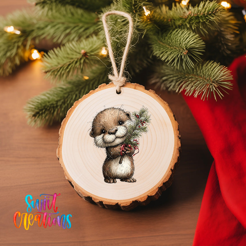 A wooden ornament featuring a cute otter holding a pine branch, hanging on a Christmas tree.