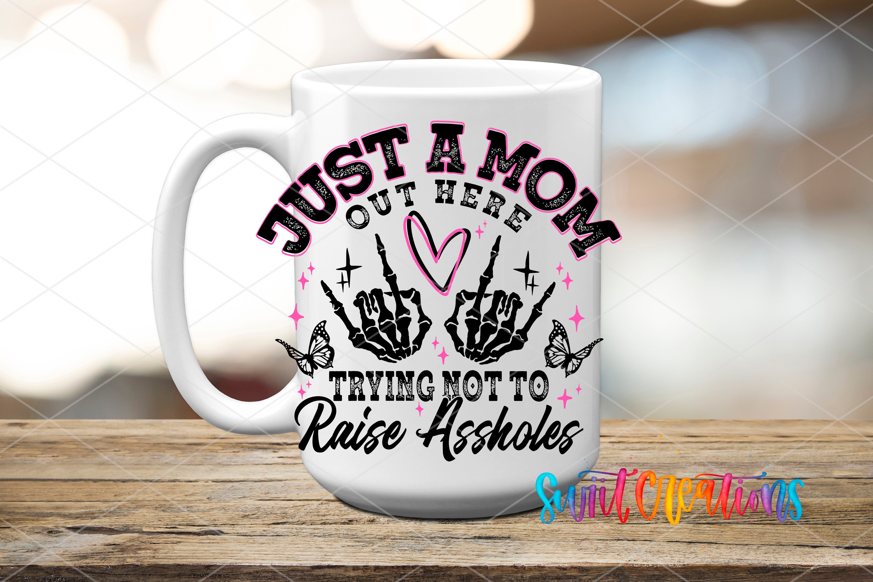 A white ceramic mug with a graphic design featuring a skeleton hand and the text "Just a Mom, out here trying not to raise hell".
