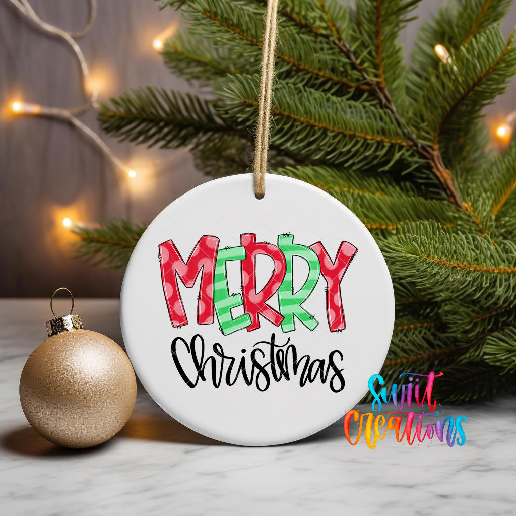 A white Christmas ornament with the text "MERRY CHRISTMAS" is displayed on a table, surrounded by a gold ornament and a pine tree with twinkling lights in the background.