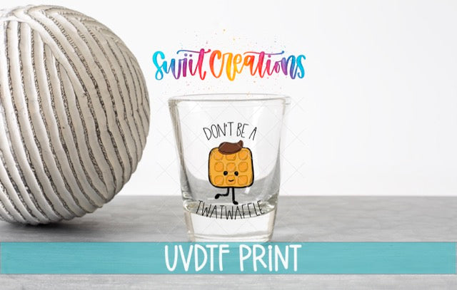 a shot glass with a cartoon waffle and the text "Don't be a waffle" printed on it, along with a colorful text overlay that says "Swift Creations" and "UVDF PRINT".