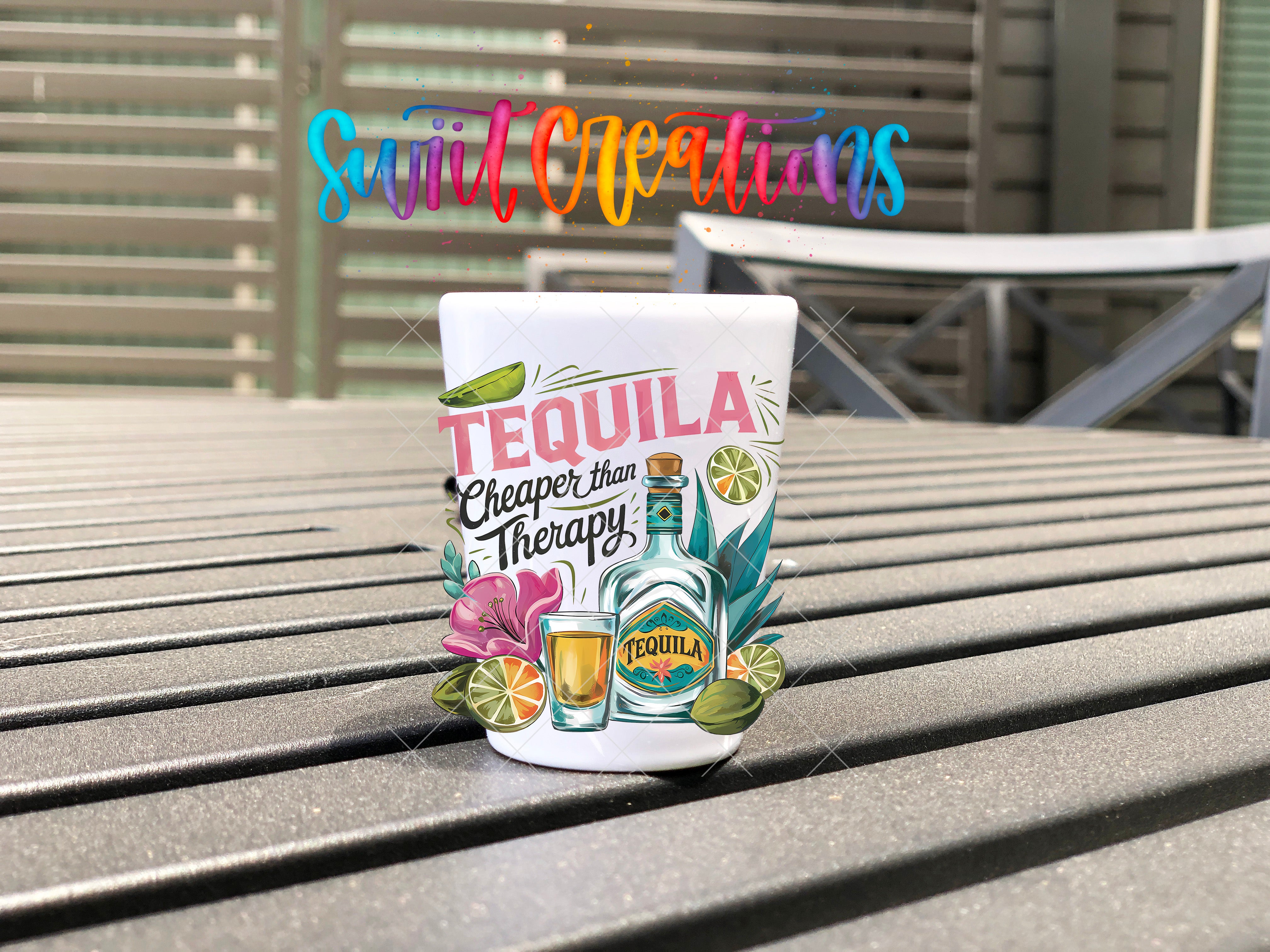 A colorful tequila-themed mug or cup with the text "Tequila Cheaper than Therapy" printed on it, placed on a wooden surface.