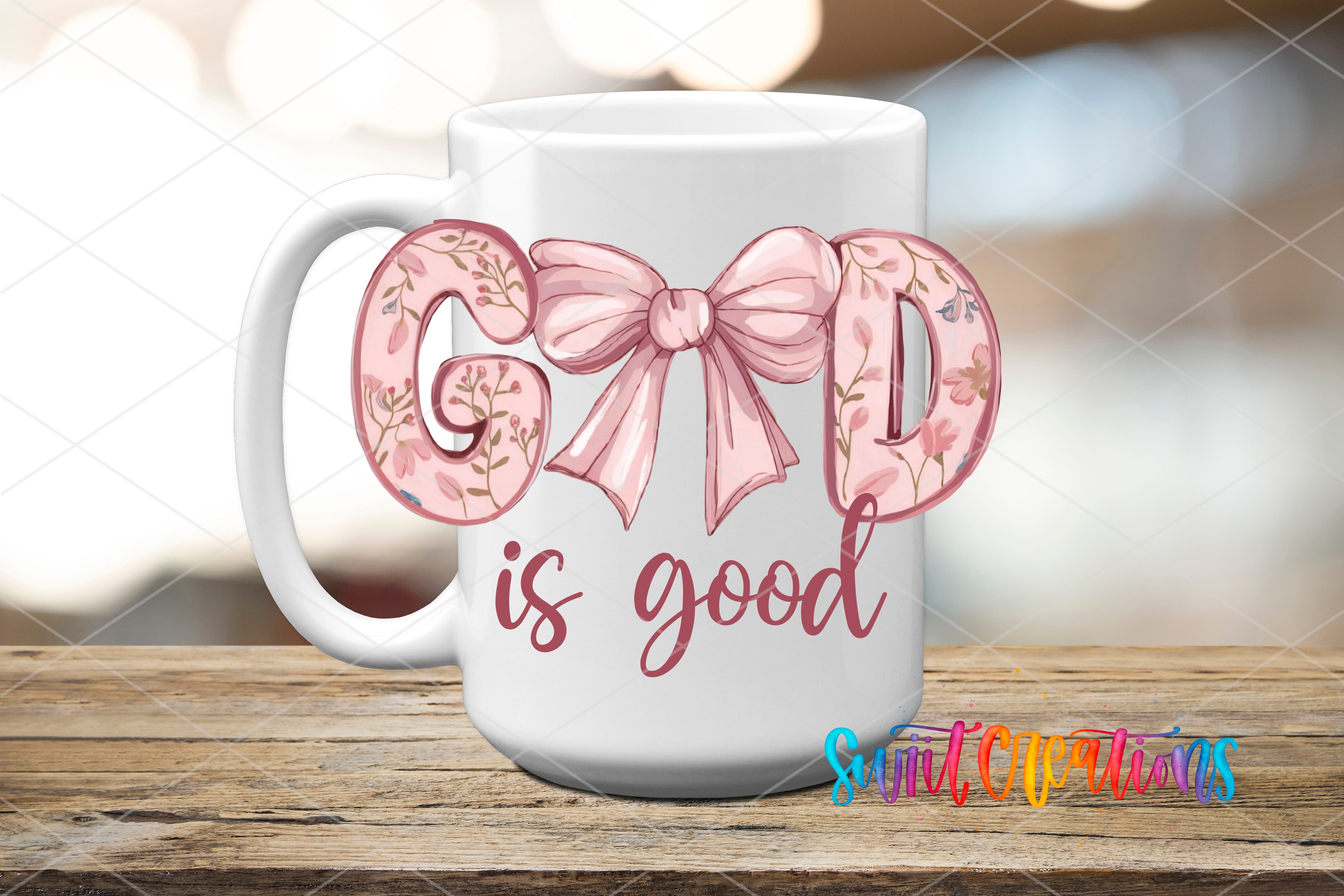 A white mug with the text "GOOD is good" printed on it, along with a bow design.