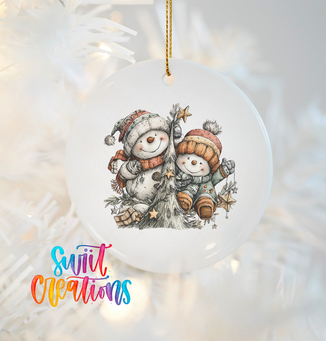 A white ornament with a snowman and a tree, featuring a colorful winter scene.