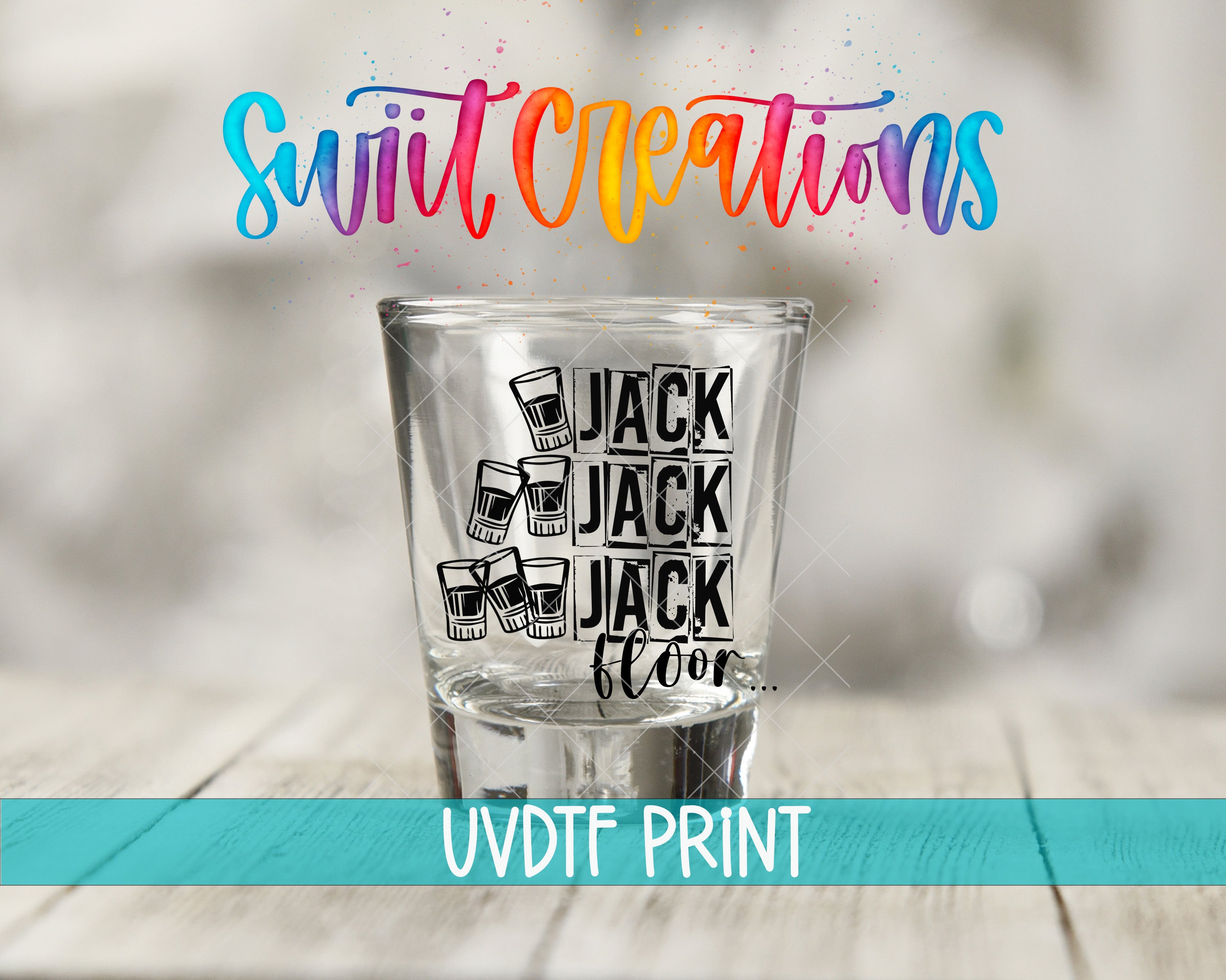 A shot glass with the text "JACK JACK FLOOR" printed on it, along with illustrations of glasses. The shot glass is placed on a wooden surface.