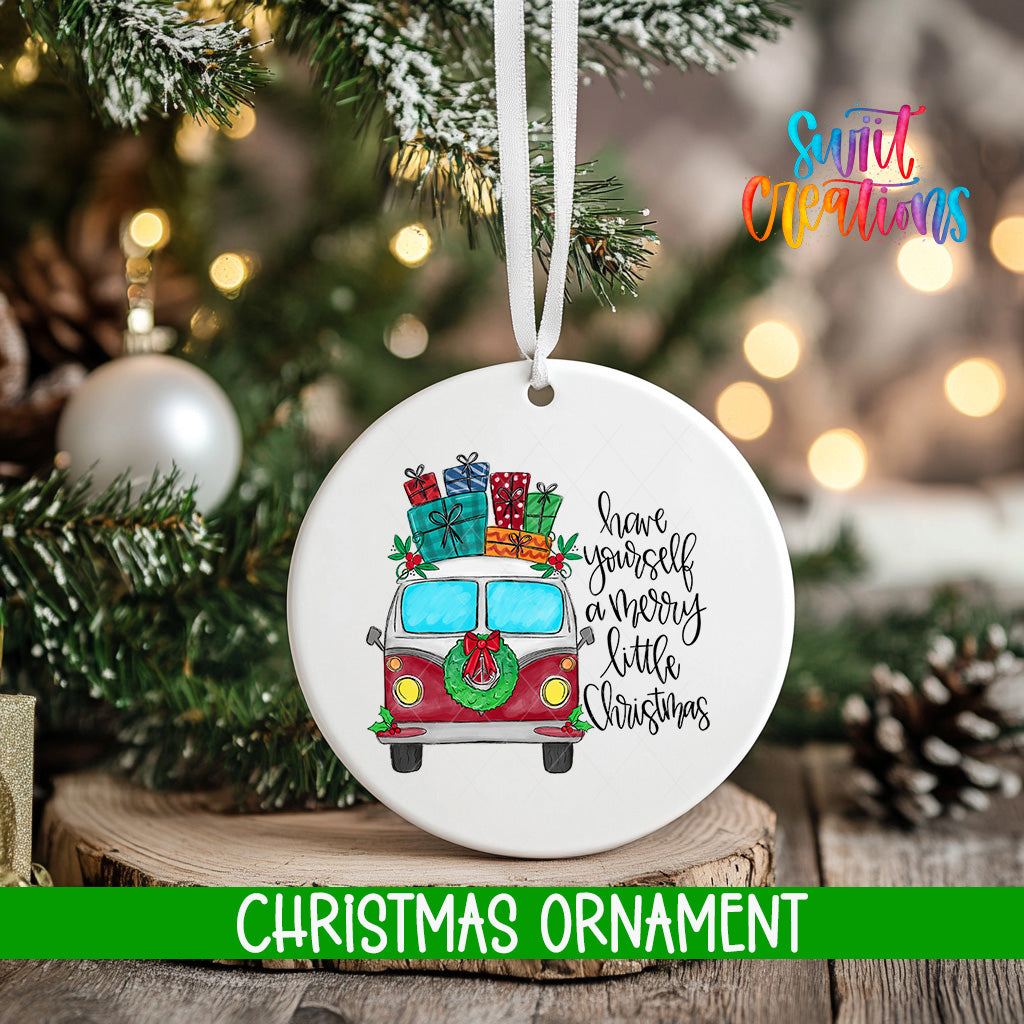 A white Christmas ornament with a red and white van decorated with presents and a wreath, hanging on a tree.