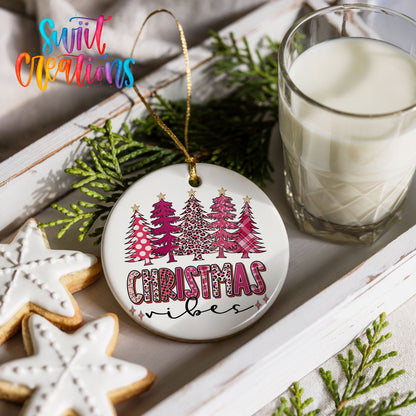 a Christmas ornament with a tree design, a glass of milk, and some cookies on a white tray.