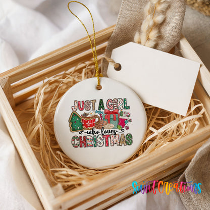 A white ceramic ornament with a colorful design, placed in a wooden crate filled with straw.