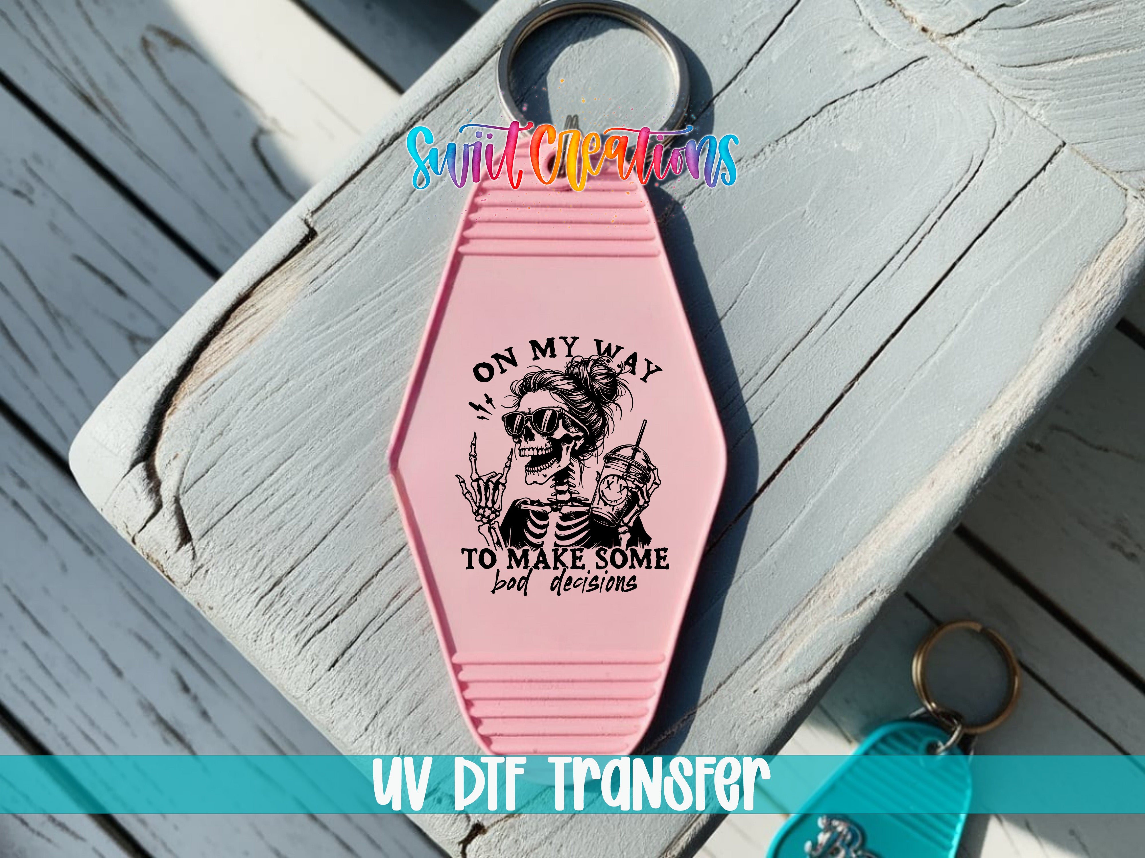 A pink keychain with a skeleton graphic and the text "ON MY WAY TO MAKE SOME BAD DECISIONS" printed on it.