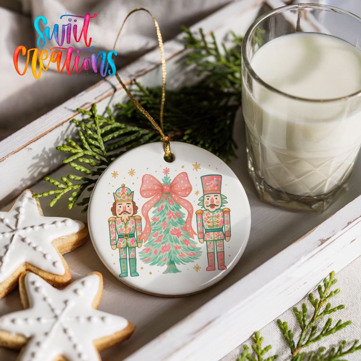 a Christmas ornament with a nutcracker and a Christmas tree, along with a glass of milk and some cookies.