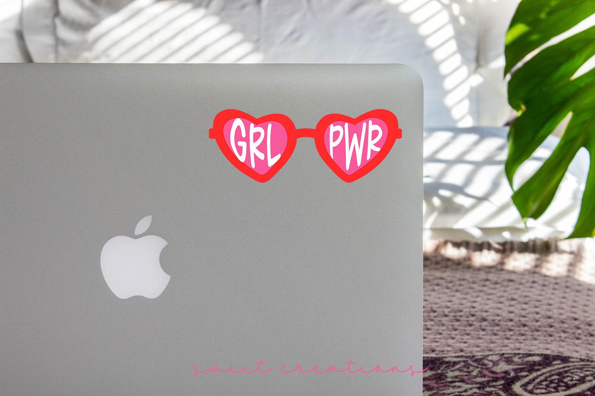 a laptop with a pair of heart shaped stickers on it