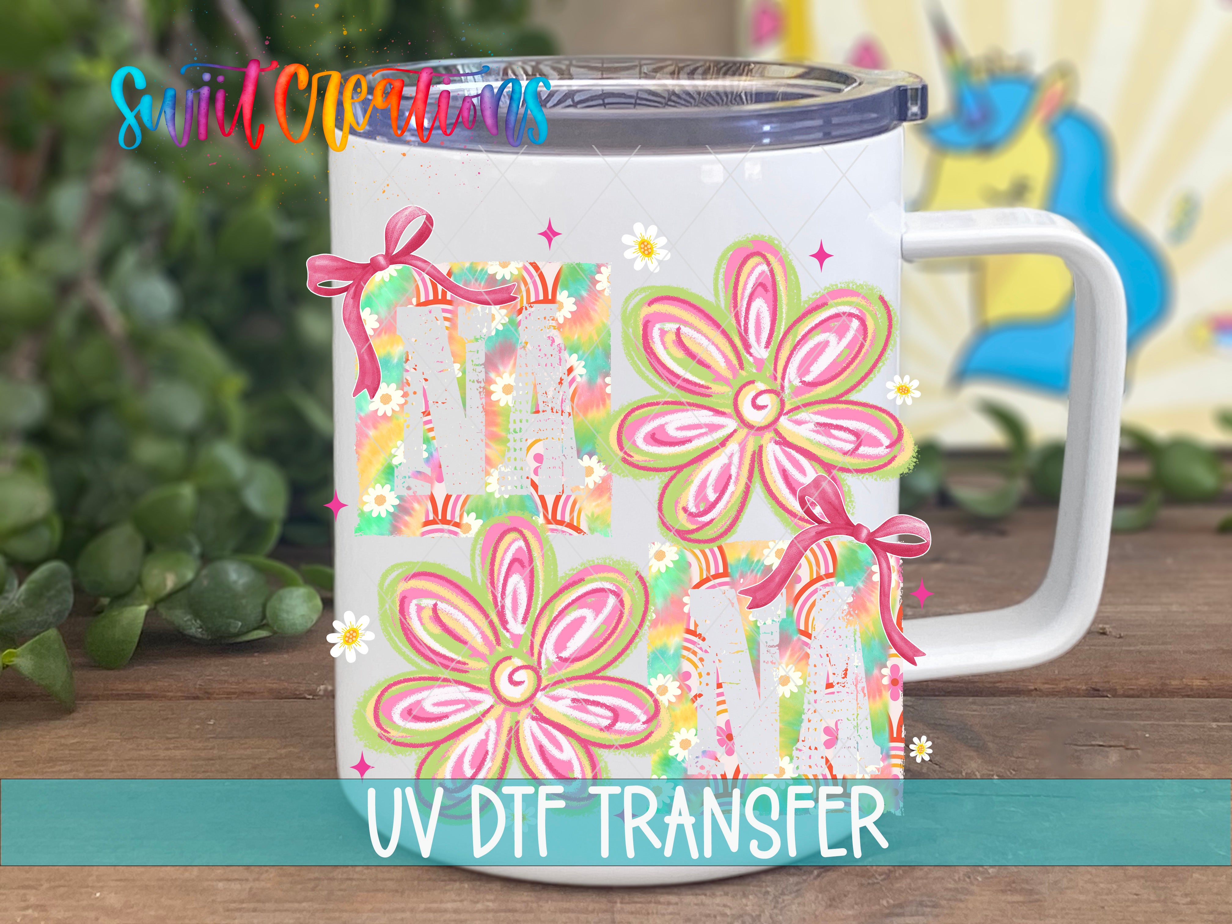 A white ceramic mug with colorful floral designs and bows, placed on a wooden surface.