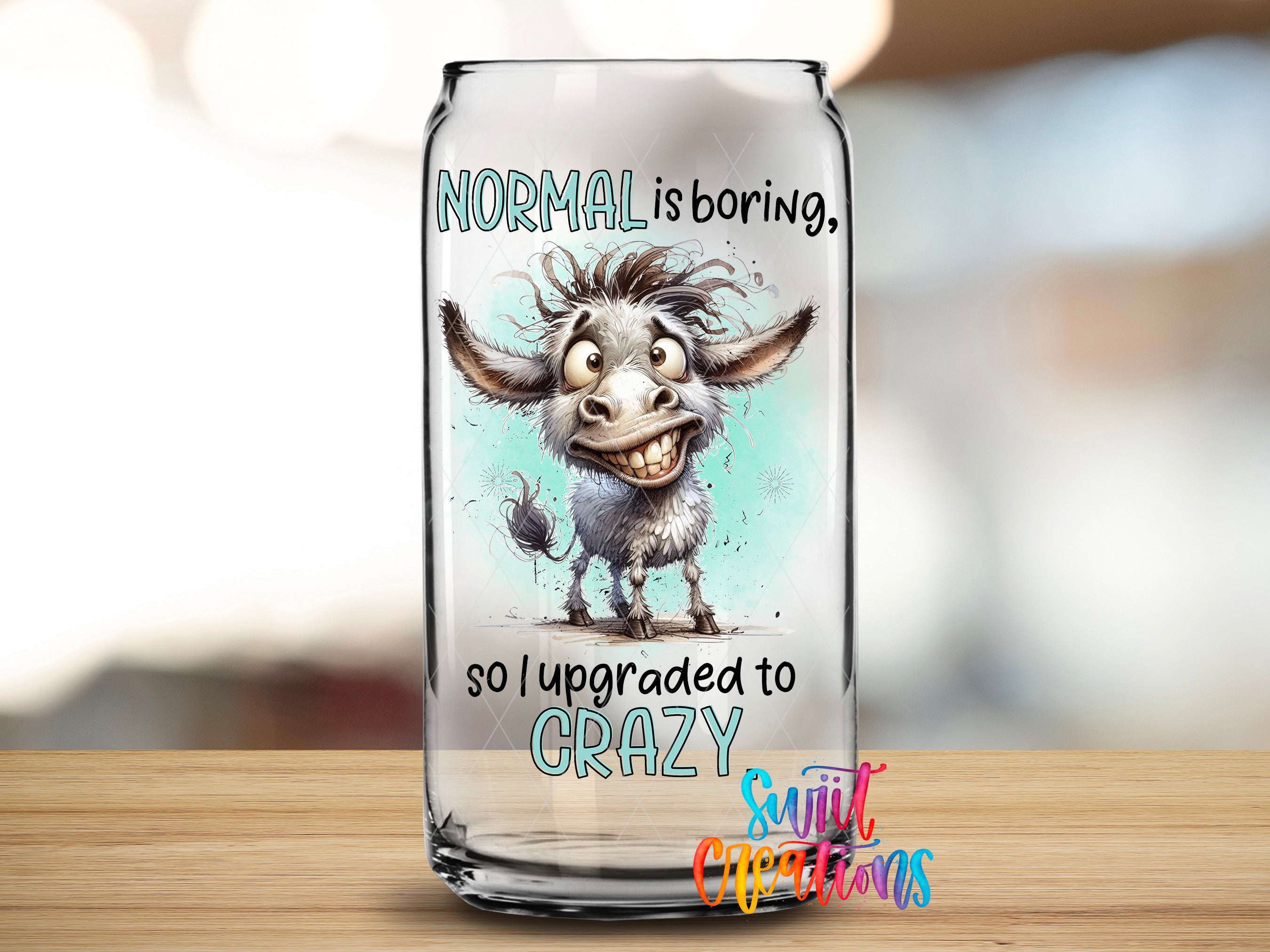A glass can with a cartoon donkey on it, along with text that reads "NORMAL is boring, so I upgraded to CRAZY".