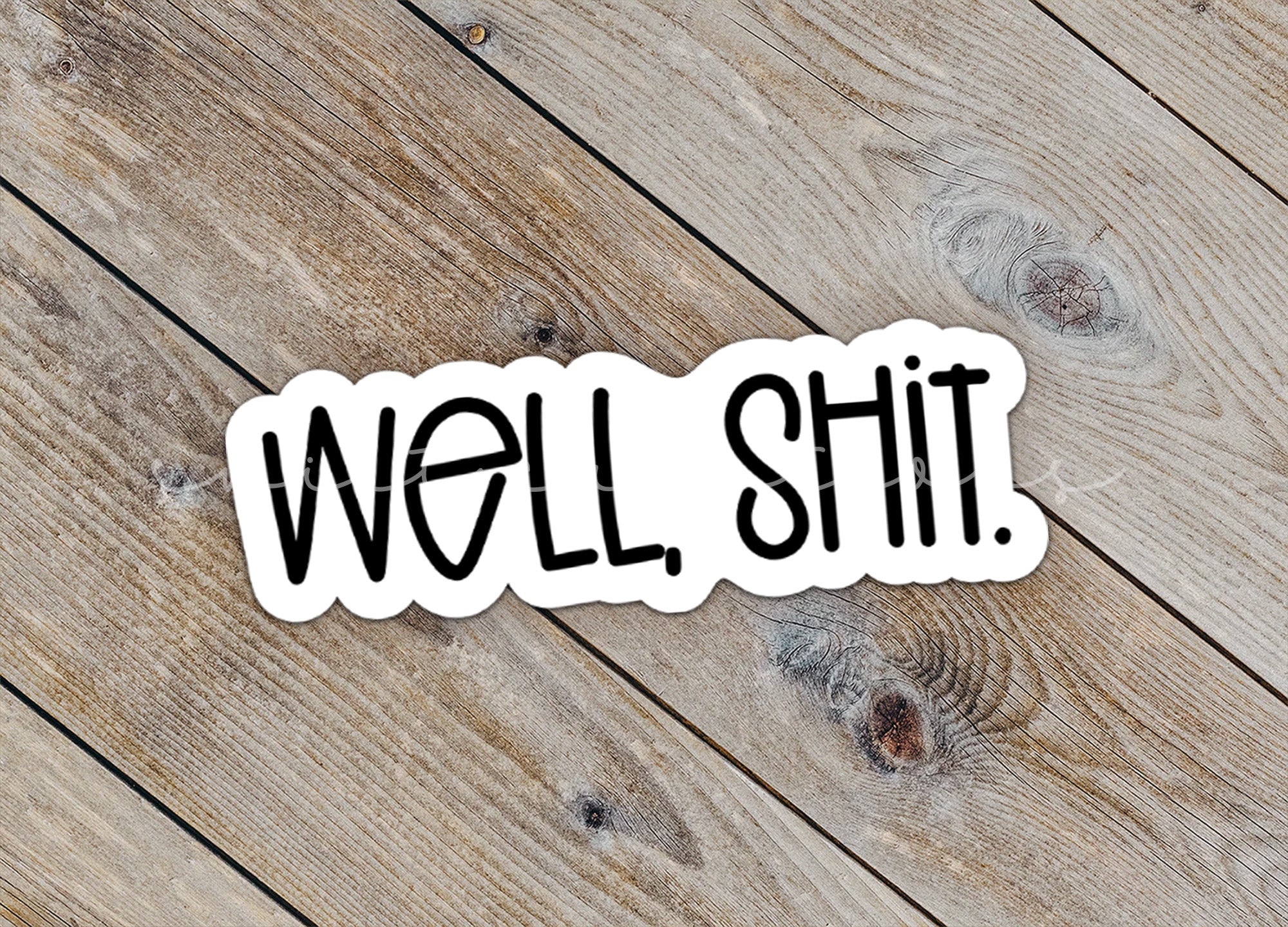 a sticker that says well shit on a wooden surface